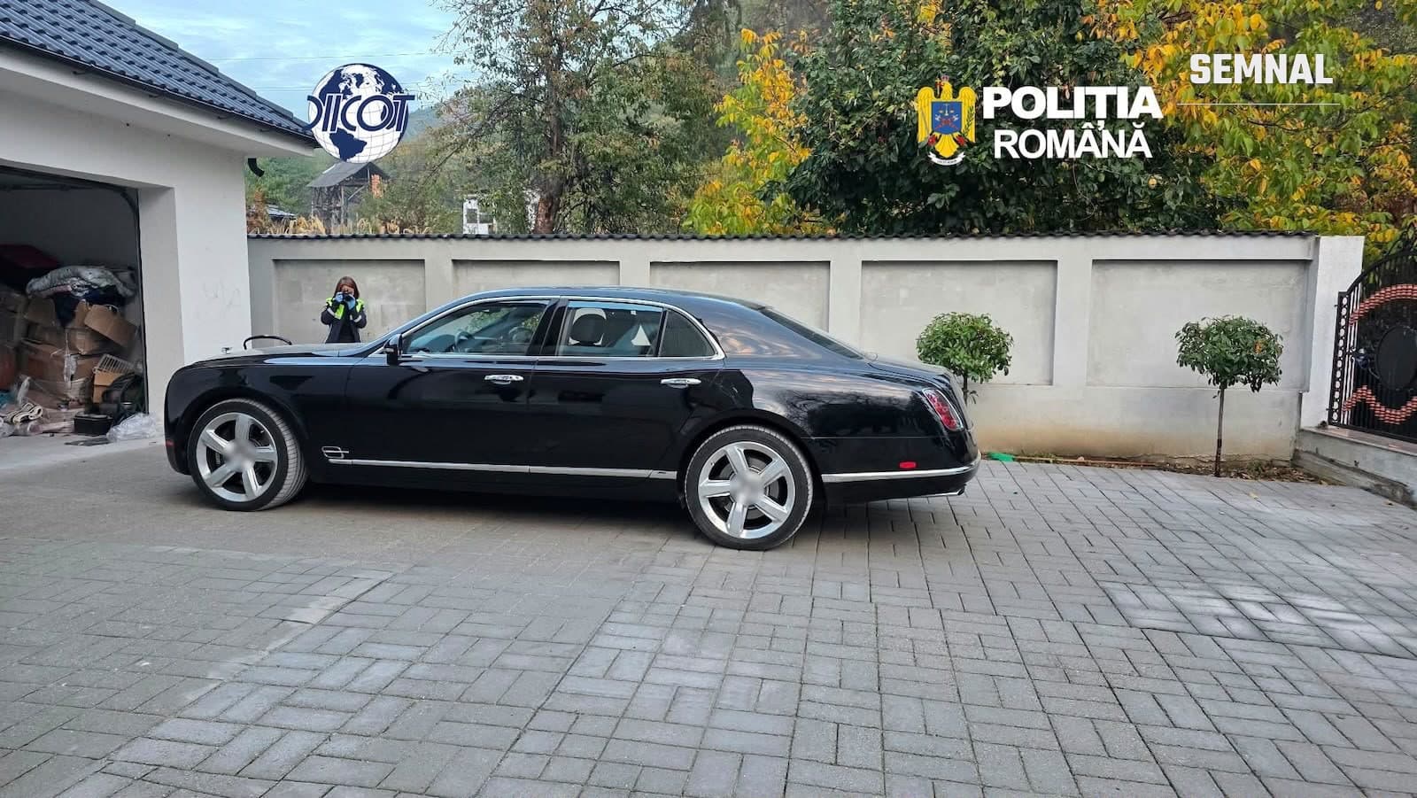 Autoturism de lux negru parcat în curtea unei locuințe, la una dintre percheziții
