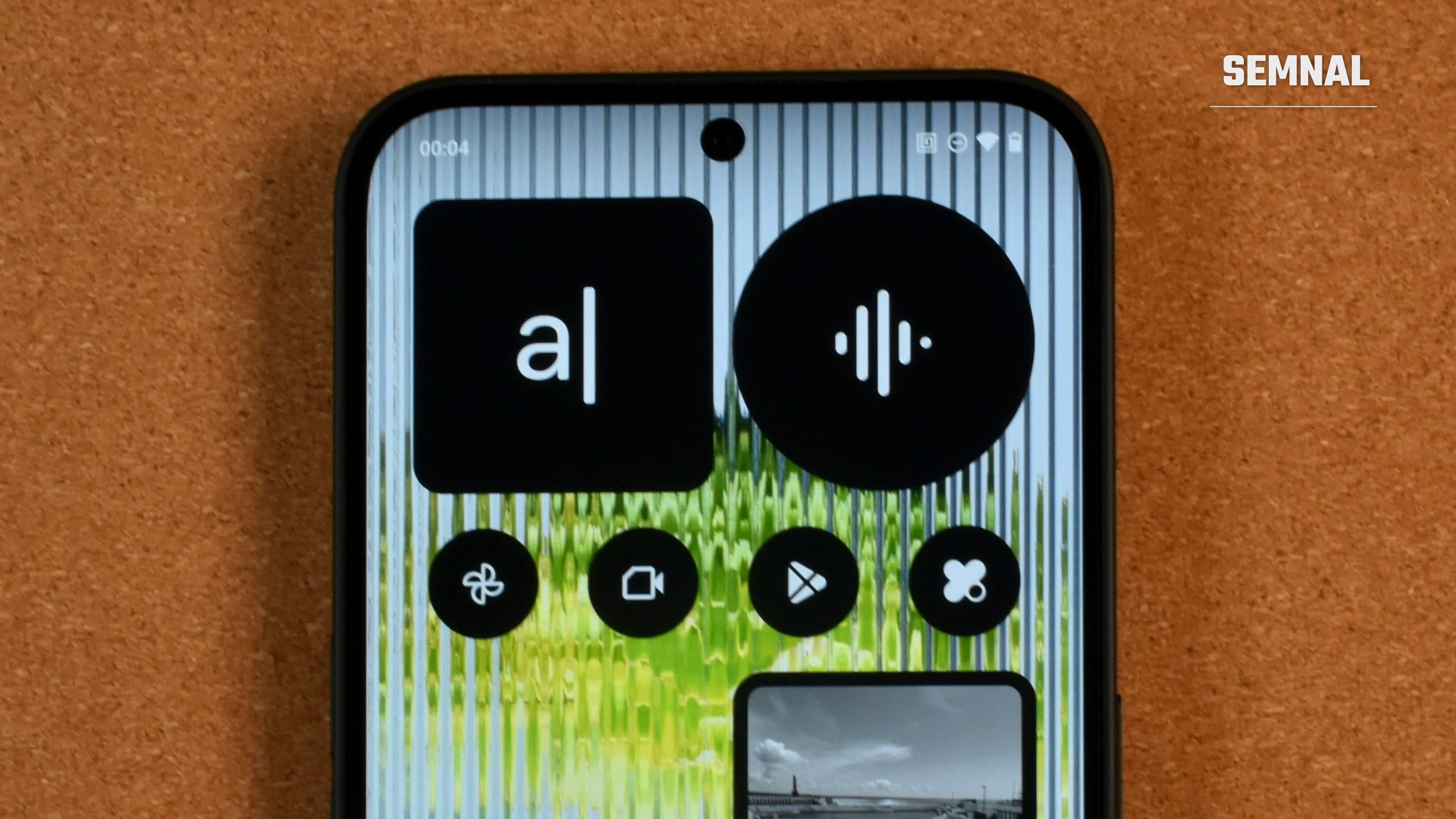 Partea de sus a ecranului aprins al unui telefon Android modern, cu bara de stare și pictograma Wi-Fi, widgeturi și aplicații pe un ecran principal personalizat, pe un fundal portocaliu din plută (Foto: Gavin Phillips / Unsplash)