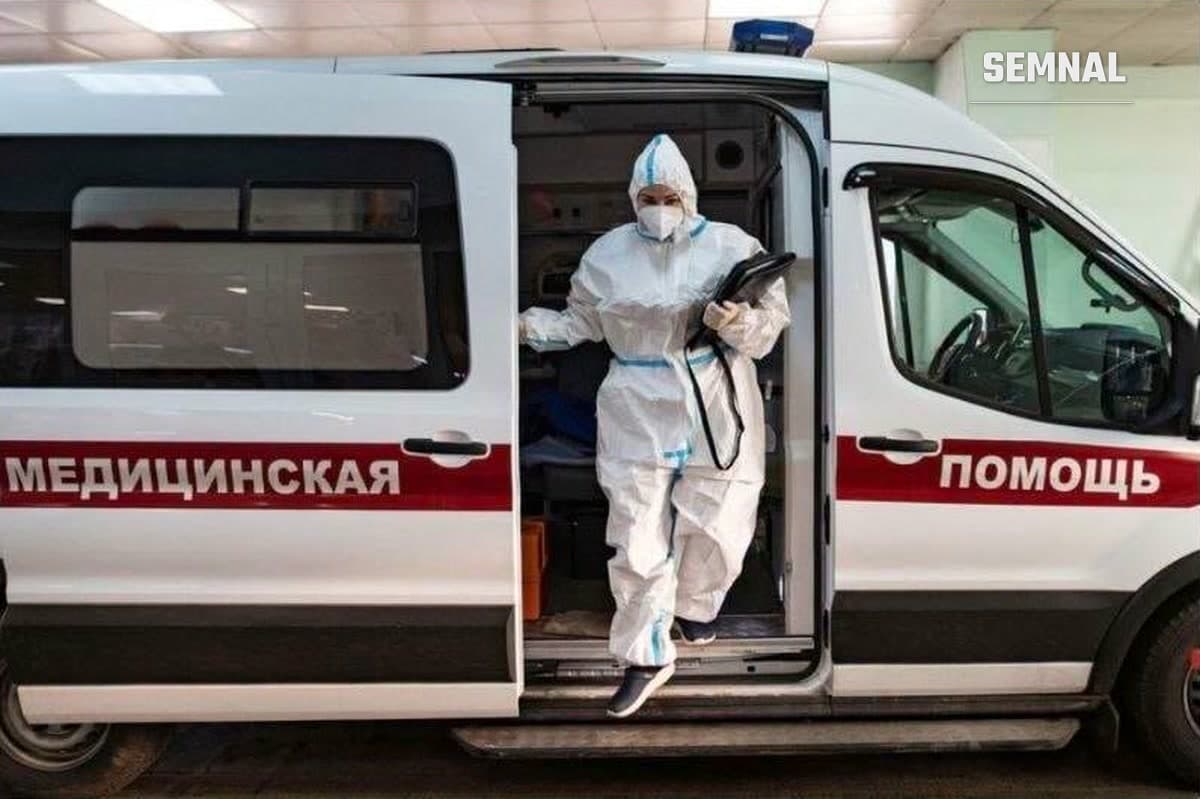 Cadru medical în costum de protecție coborând dintr-o ambulanță, în Rusia
