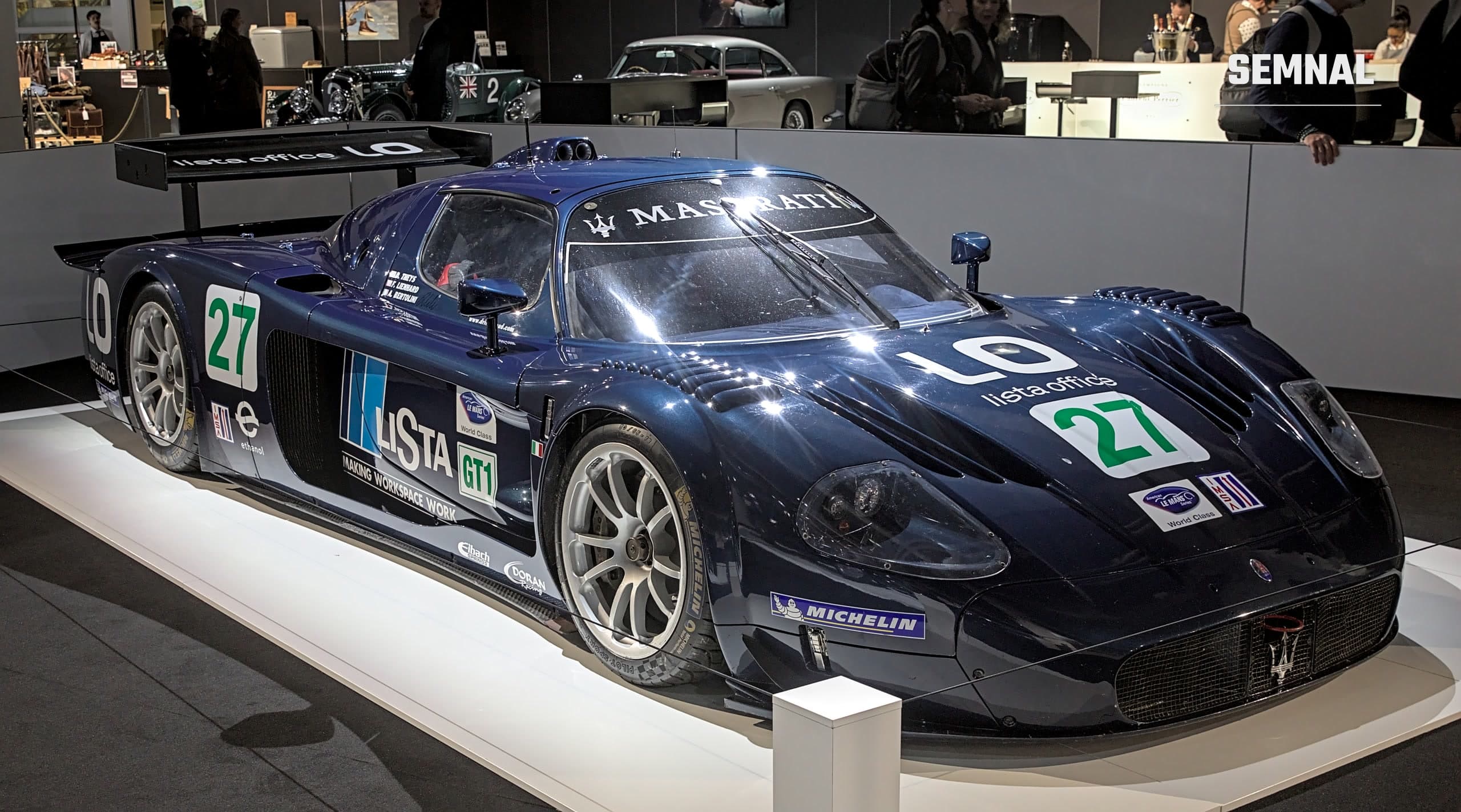 Maserati MC12 GT1 albastru închis, cu numărul 27 și sigle de sponsori pe caroserie, expus pe un podium la Auto Zürich 2023