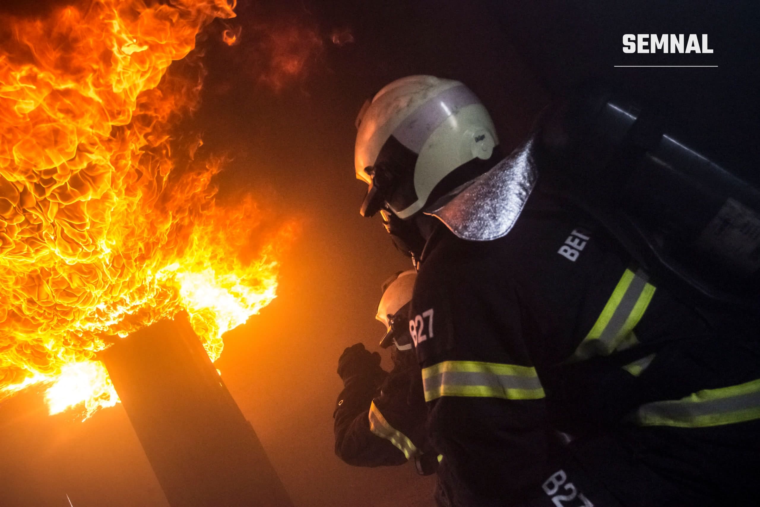 Pompieri intervenind la un incendiu puternic, cu flăcări mari, în timpul nopții