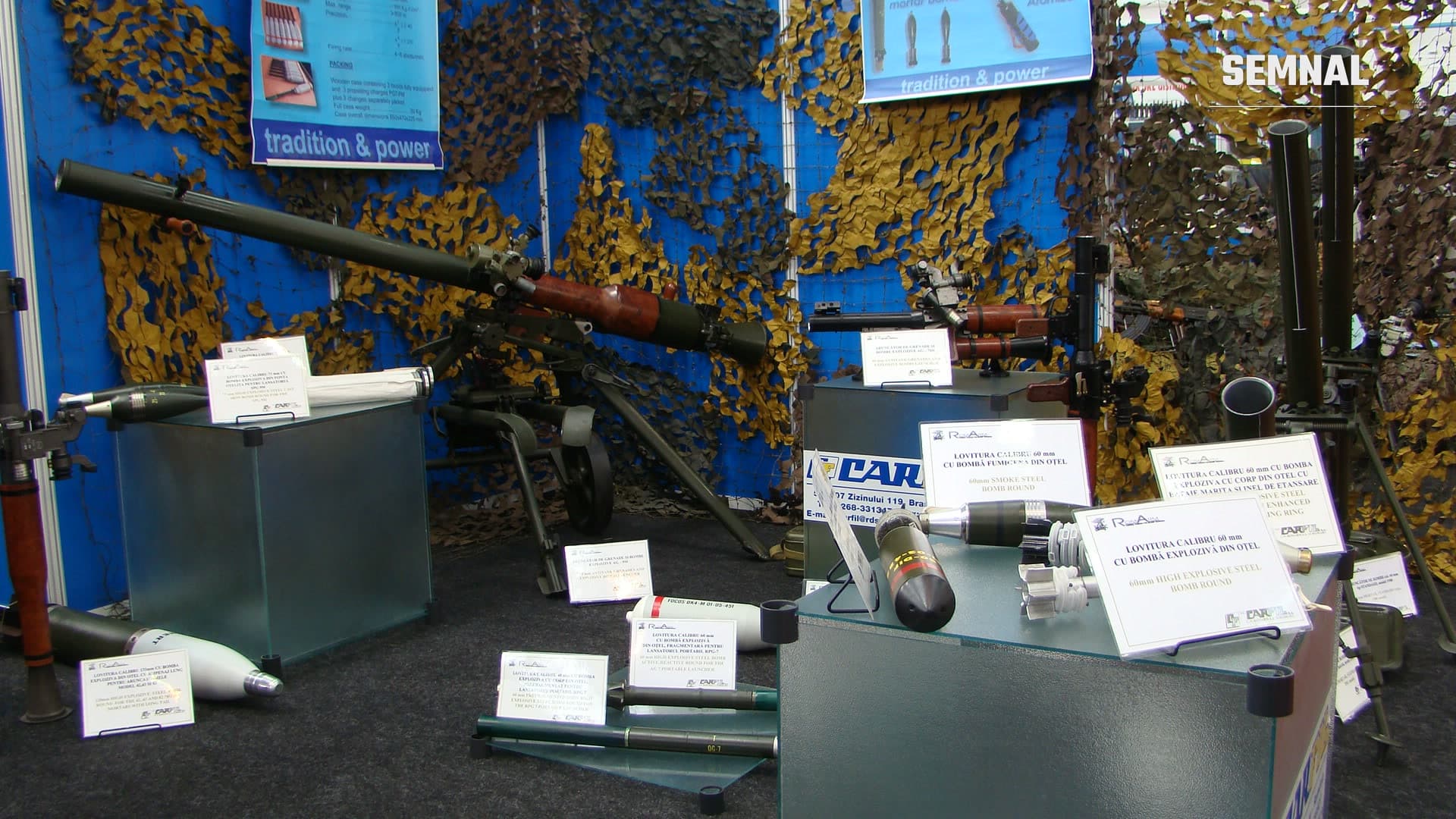 Stand Carfil la salonul Black Sea Defense and Aerospace 2010, cu lansatoare de grenade AG-7 și AG-9, mortiere și proiectile pe fundal albastru cu plase de camuflaj