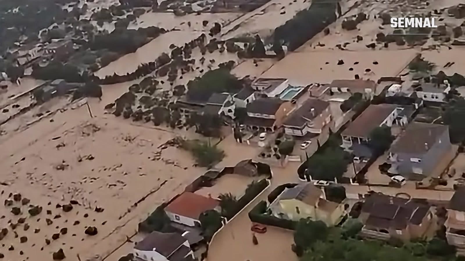 Vedere aeriană a unui cartier de case din Oliva, cu străzi și terenuri acoperite de apă noroioasă după inundații