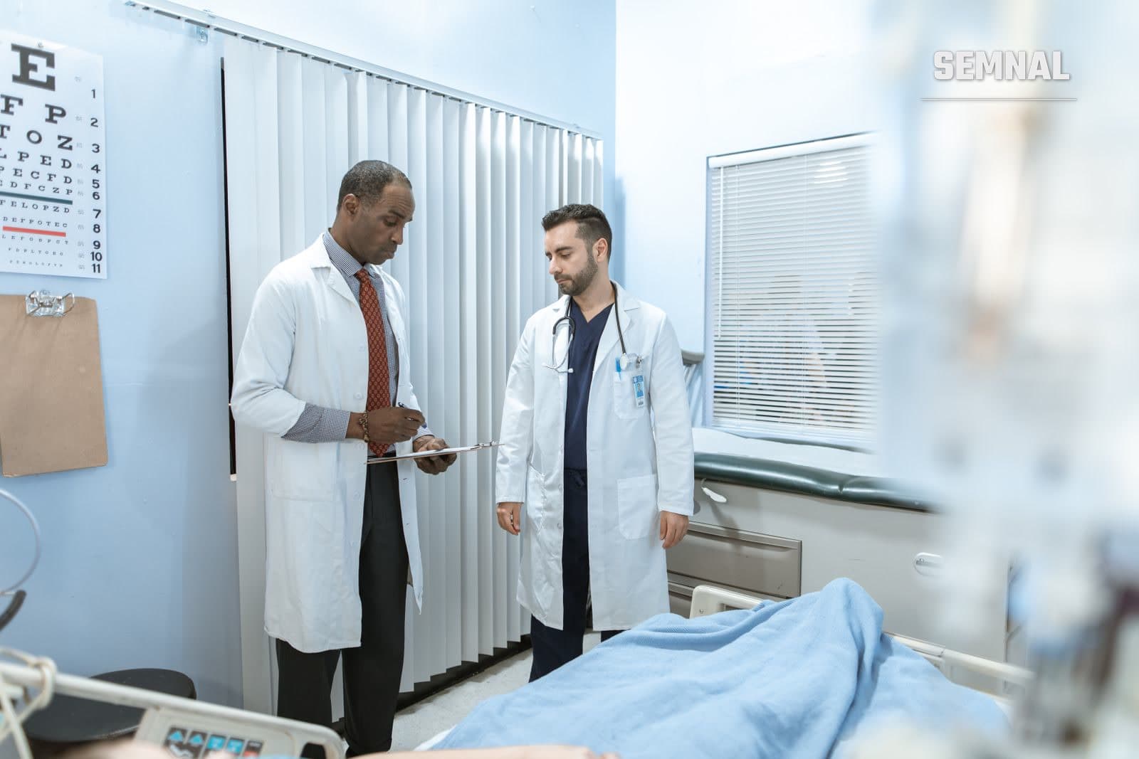 Doi medici discută despre un dosar medical într-un salon de spital, fotografie ilustrativă