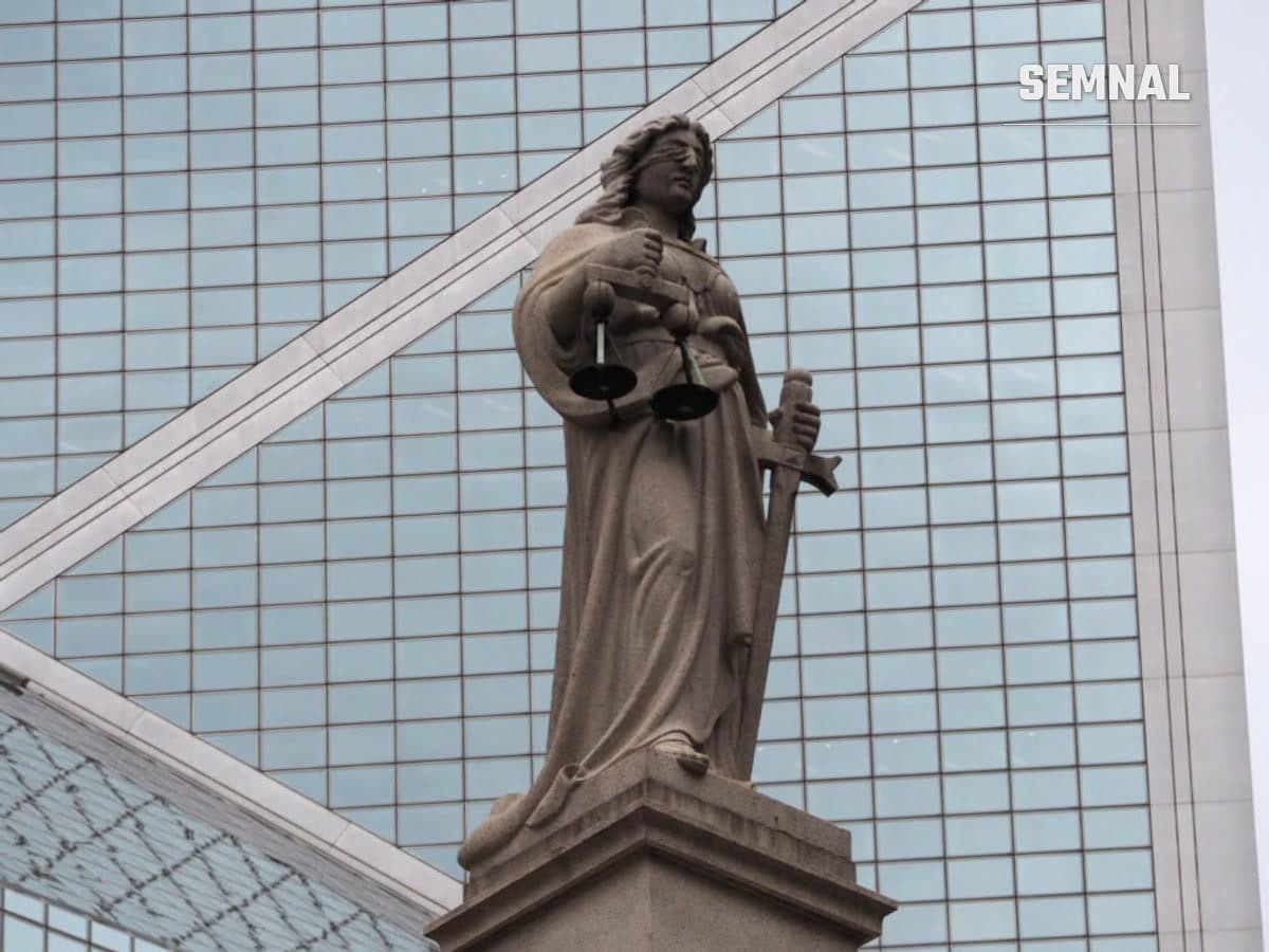 Statuie a Justiției cu balanța și sabia, în fața unei clădiri de sticlă, fotografie ilustrativă