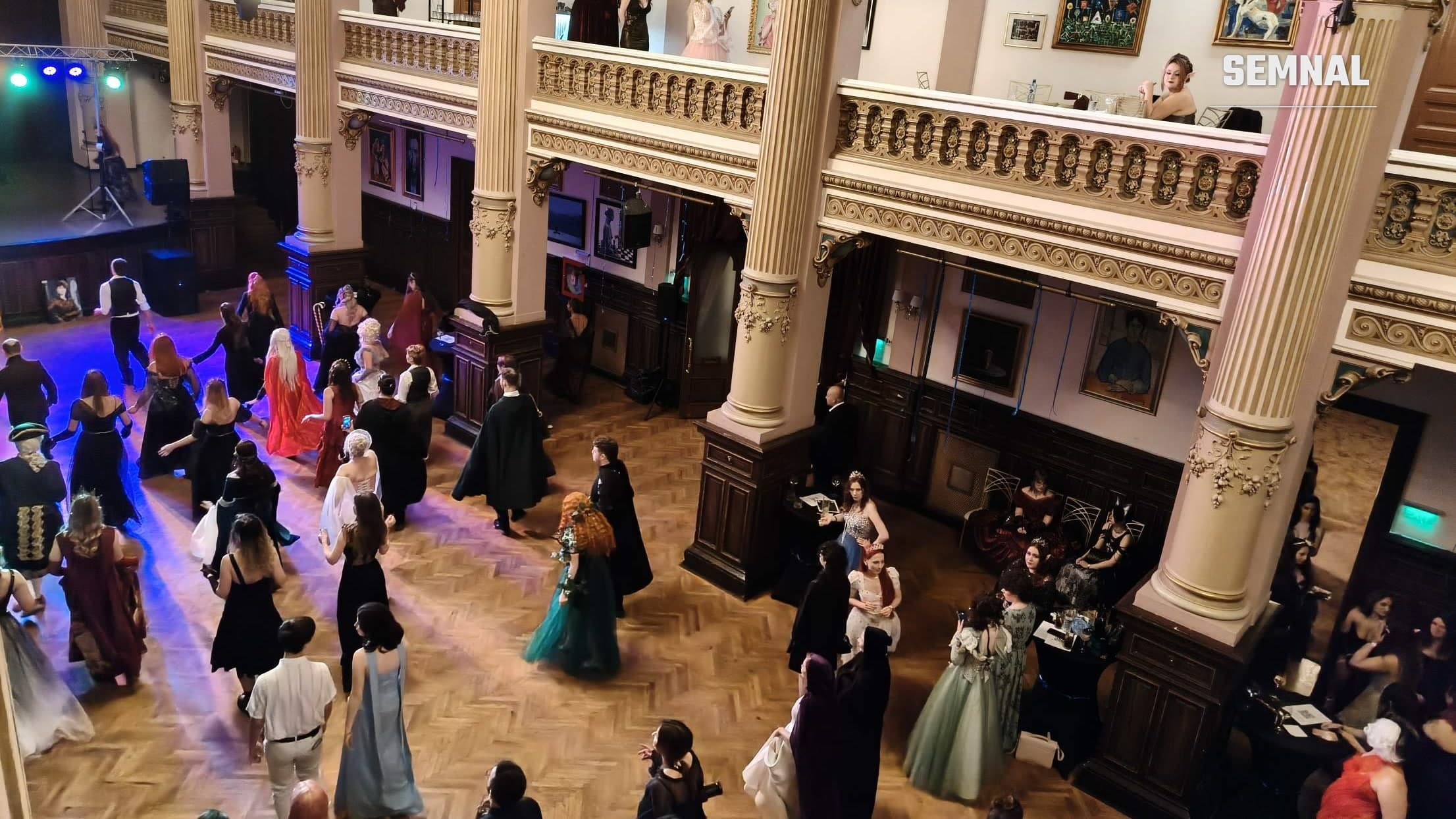 Invitați în costume fantasy dansează pe ringul din sala cu coloane a Palatului Bragadiru, văzuți de la balcon