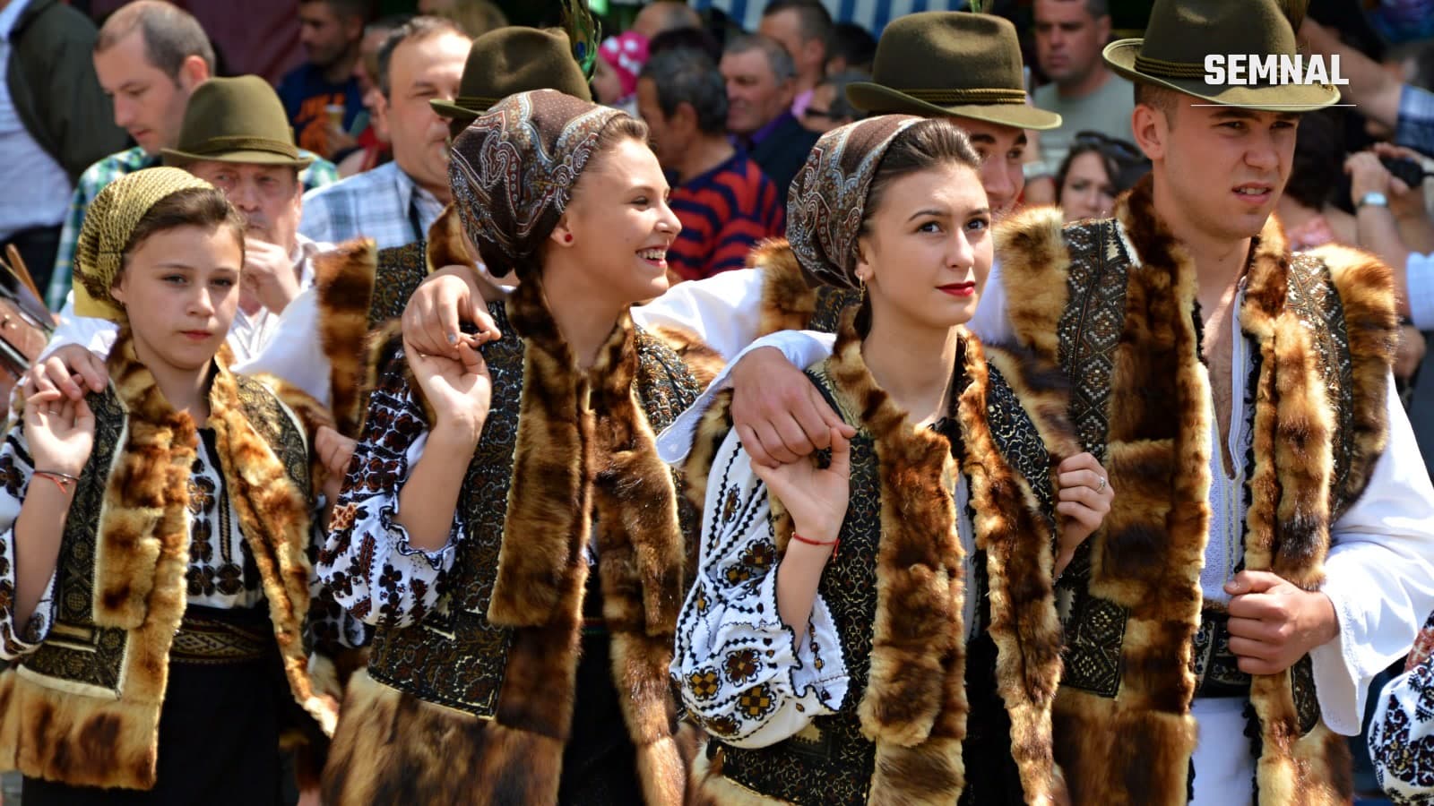Tineri în port popular, cu vestă de blană și cămăși brodate, dansează la festivalul Hora Bucovinei din Frasin.