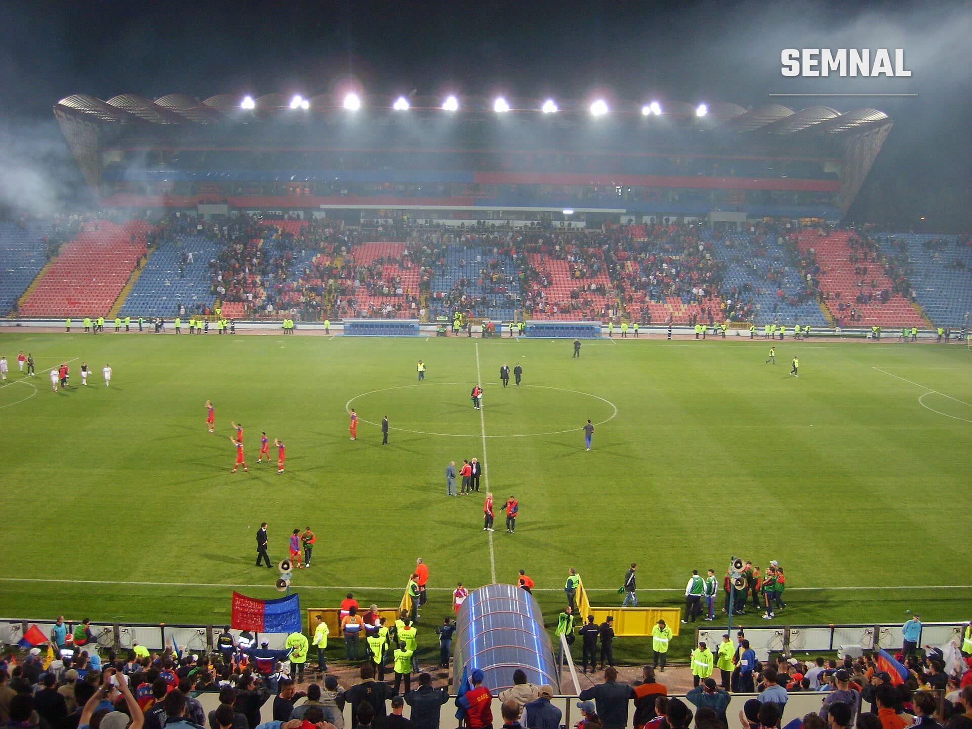 Stadionul Ghencea din București, în timpul unui meci nocturn, cu tribunele în culorile roșu și albastru