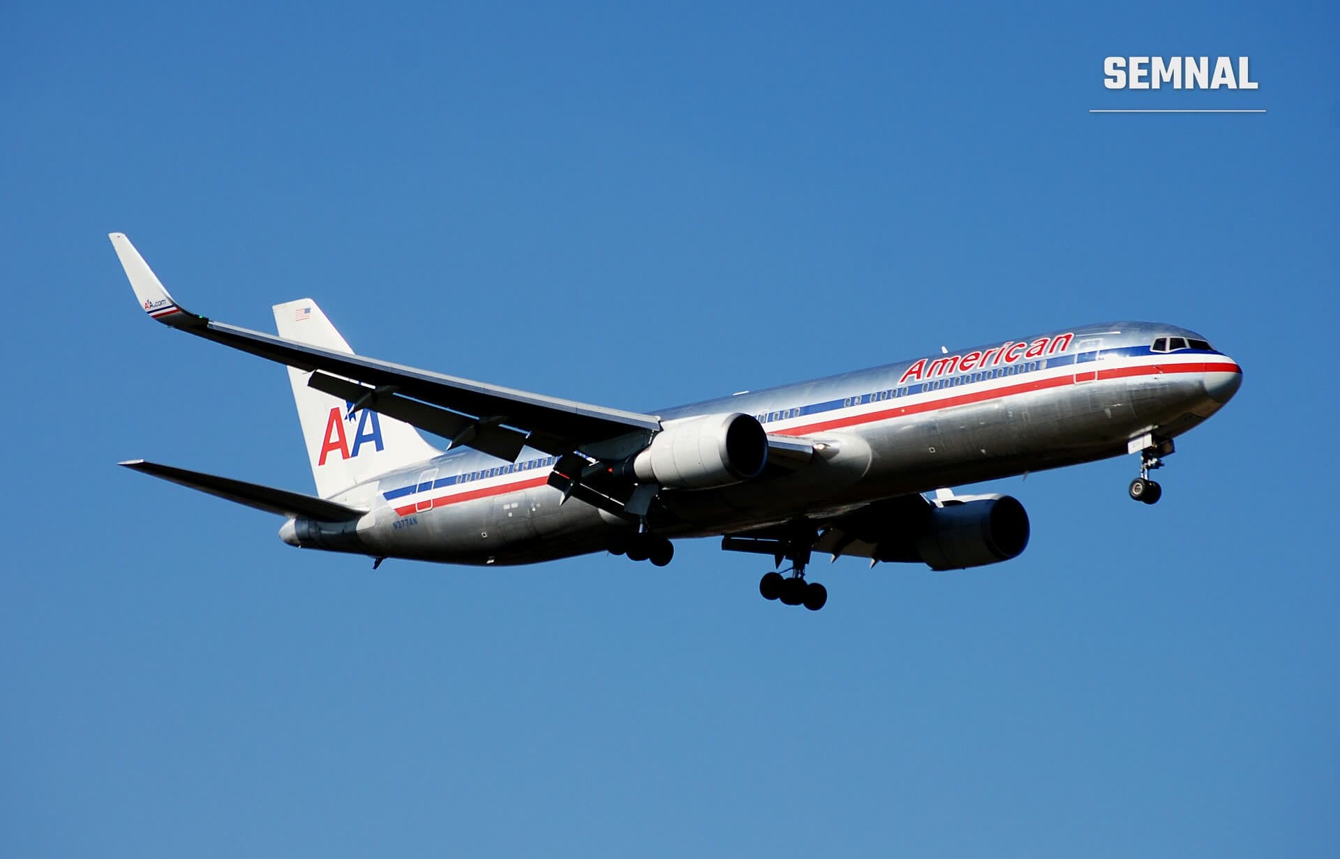 Un Boeing 767 al American Airlines, cu fuselaj argintiu, în apropierea aterizării, pe cer senin