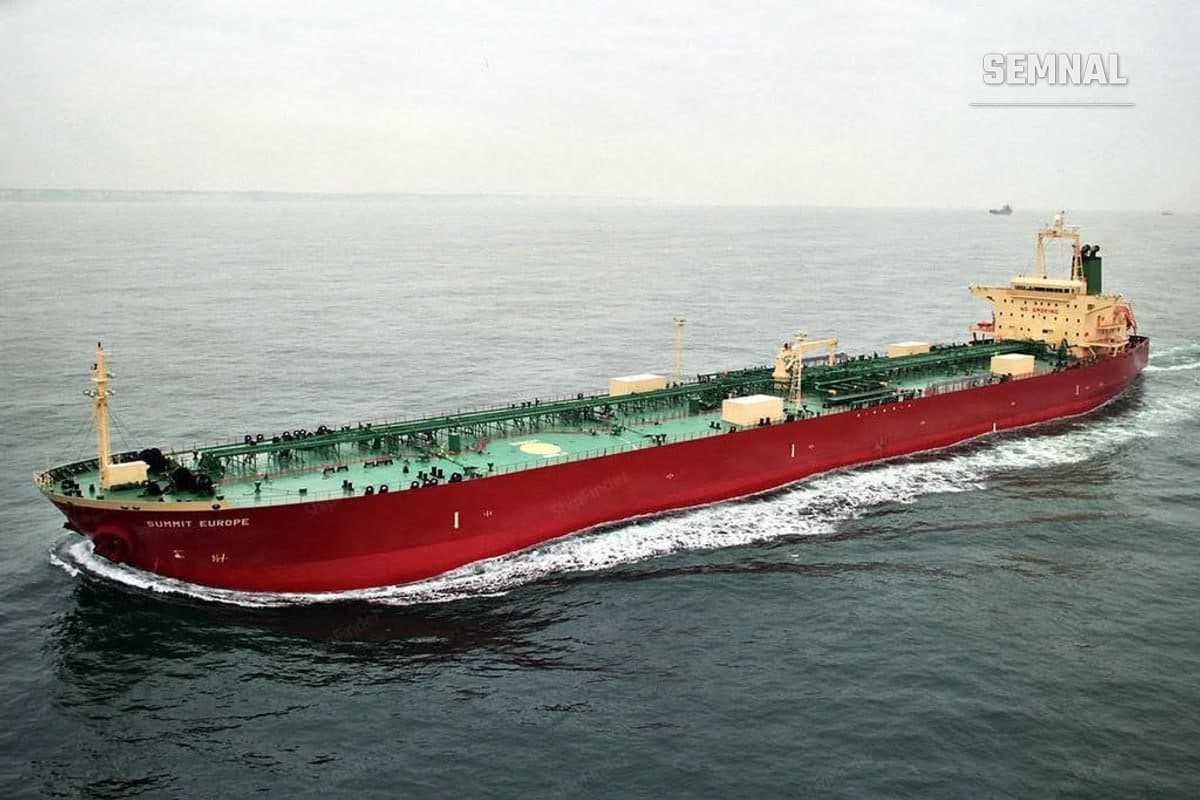 Petrolier cu cocă roșie și punte verde navigând pe mare calmă, fotografiat pe vremea când purta numele Summit Europe