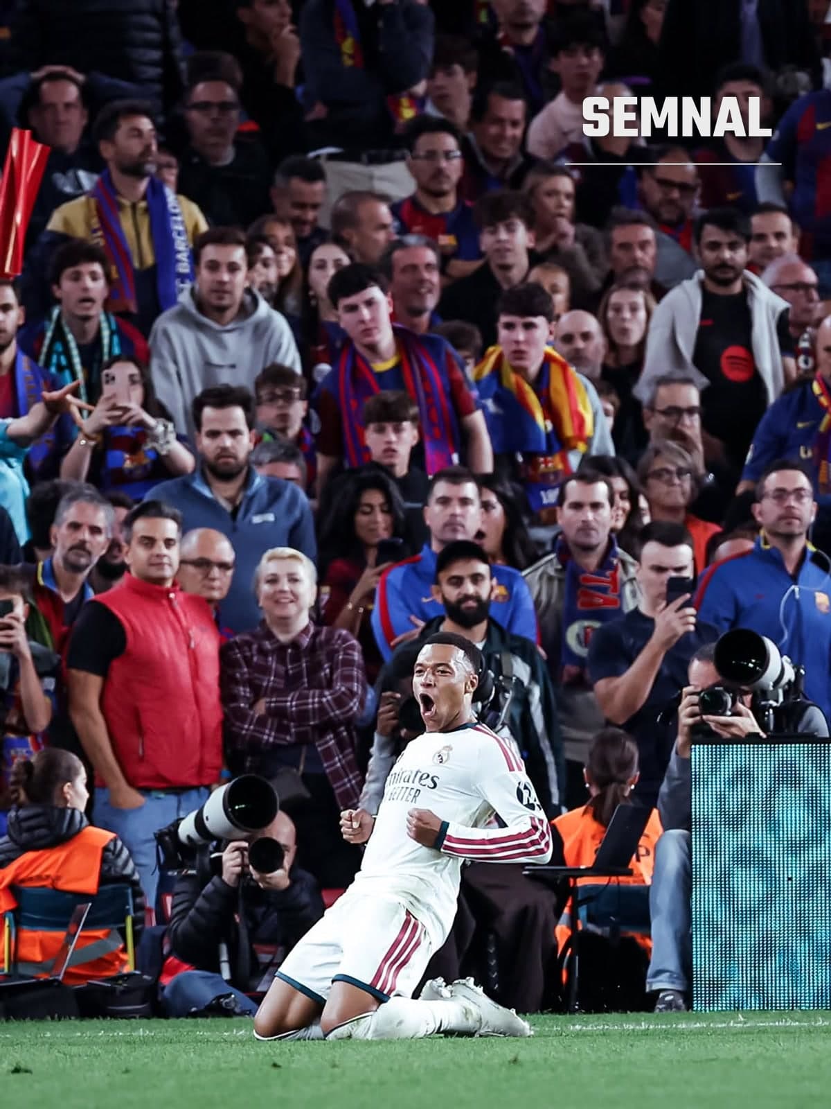 Kylian Mbappé, în echipamentul alb al lui Real Madrid, se bucură în genunchi lângă tribuna cu suporteri ai Barcelonei, pe Camp Nou