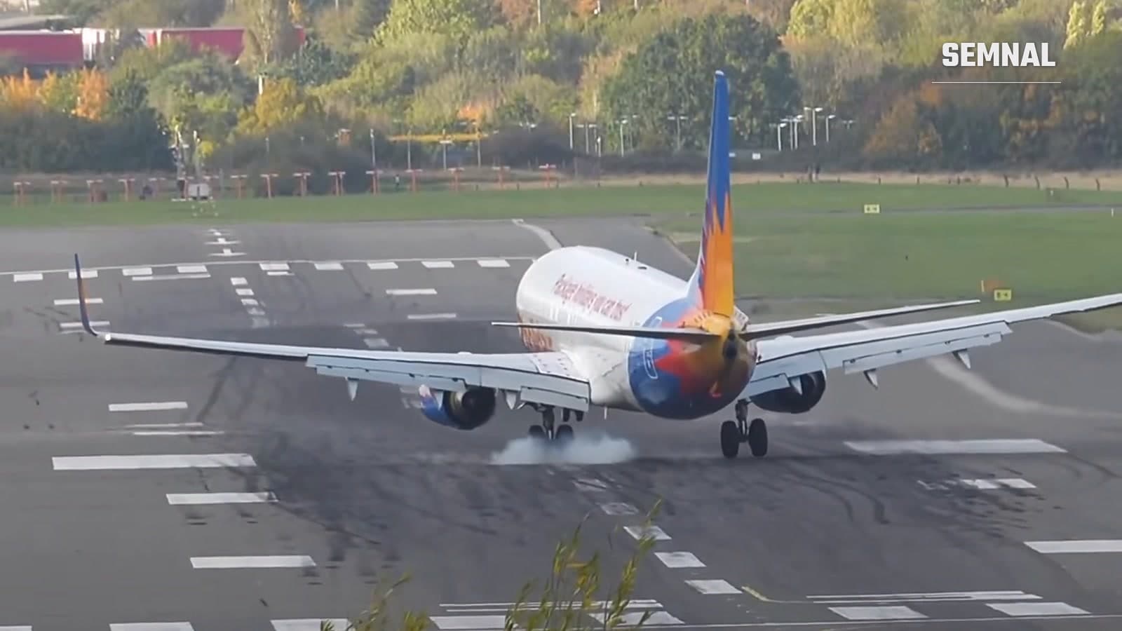 Boeing 737 al Jet2, văzut din spate, în momentul contactului cu pista la Aeroportul Birmingham, cu fum ușor din pneuri