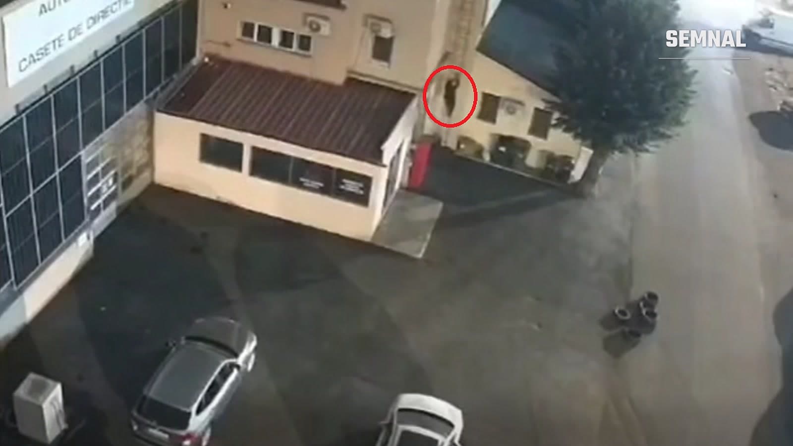 Captură dintr-un clip video publicat de SRI, în care o persoană încercuită în roșu se află pe o scară, lângă o clădire