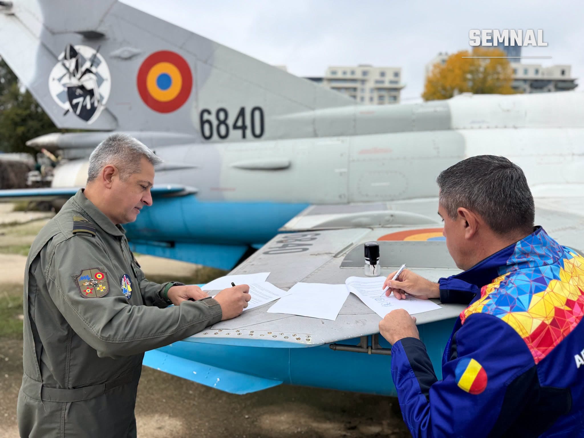 Reprezentanții Aeroclubului României și ai Muzeului Aviației semnează protocolul pe aripa unui MiG-21 cu numărul 6840