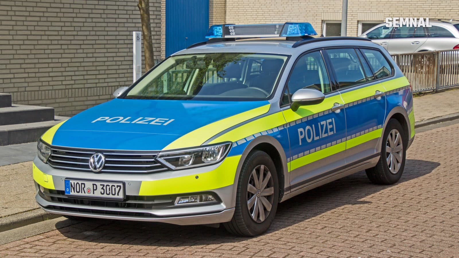 Autoturism al poliției din Saxonia Inferioară, în culorile albastru și galben-fluorescent, parcat pe o stradă. Imagine ilustrativă.