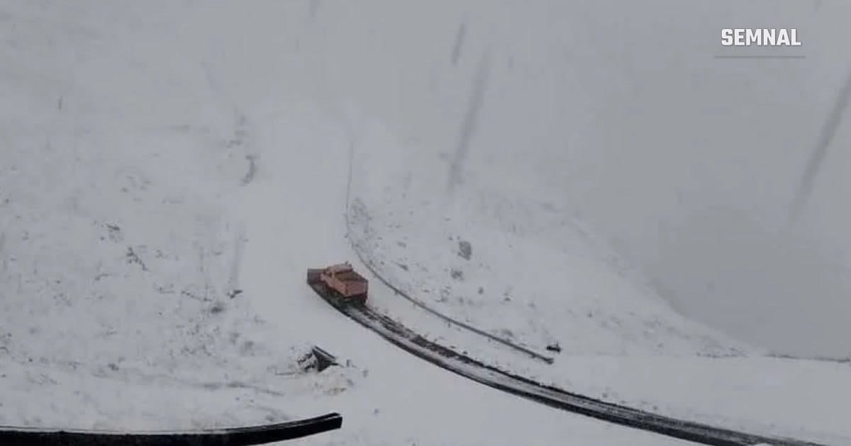 Un utilaj de deszăpezire portocaliu circulă pe un drum de munte acoperit de zăpadă, pe Transfăgărășan, în timpul ninsorii. (Foto: Facebook / CNAIR)