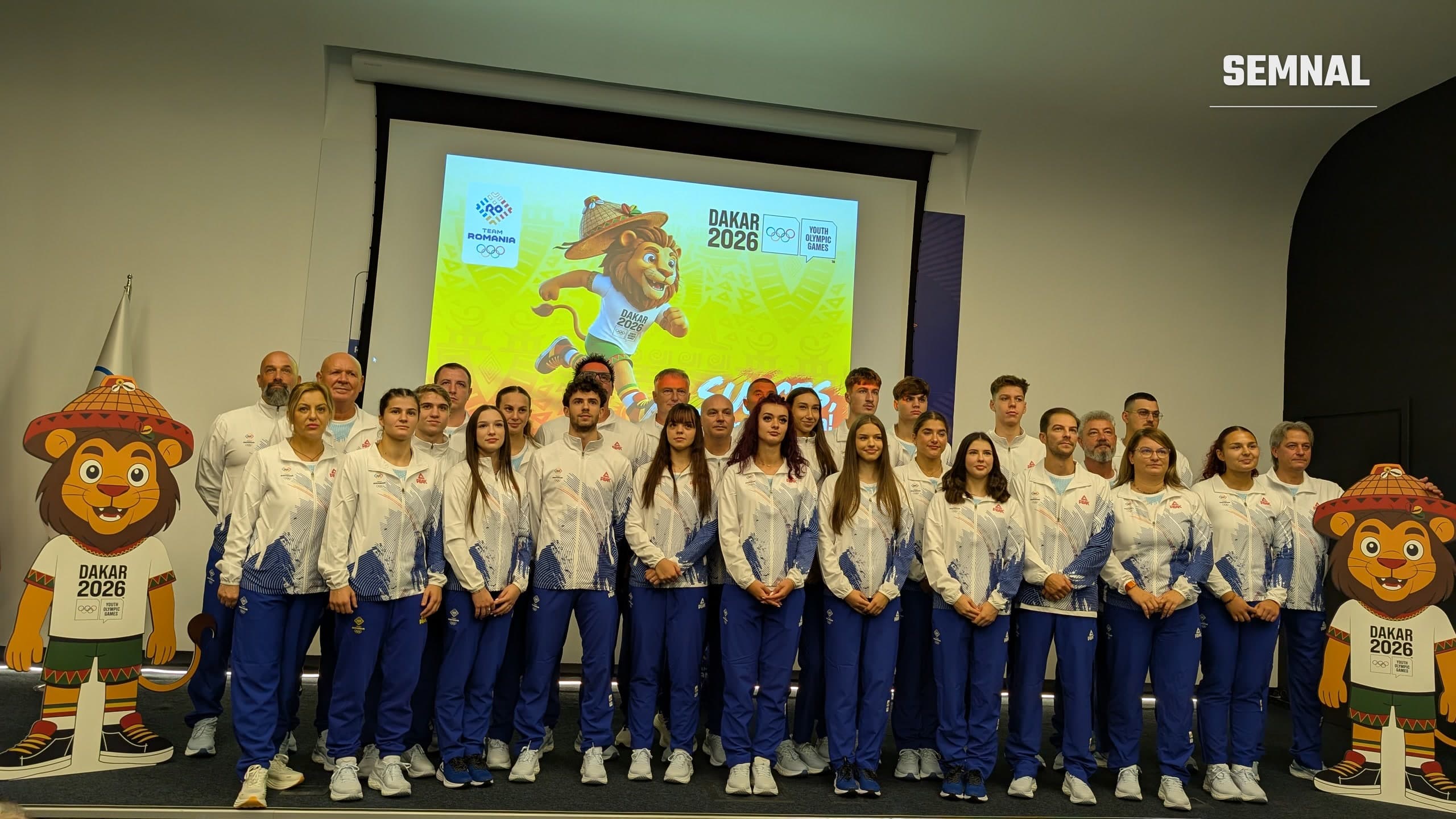 Sportivii lotului României pentru Jocurile Olimpice de Tineret Dakar 2026, în echipament alb Team Romania, pe scena Casei Olimpice din București, alături de mascota leu