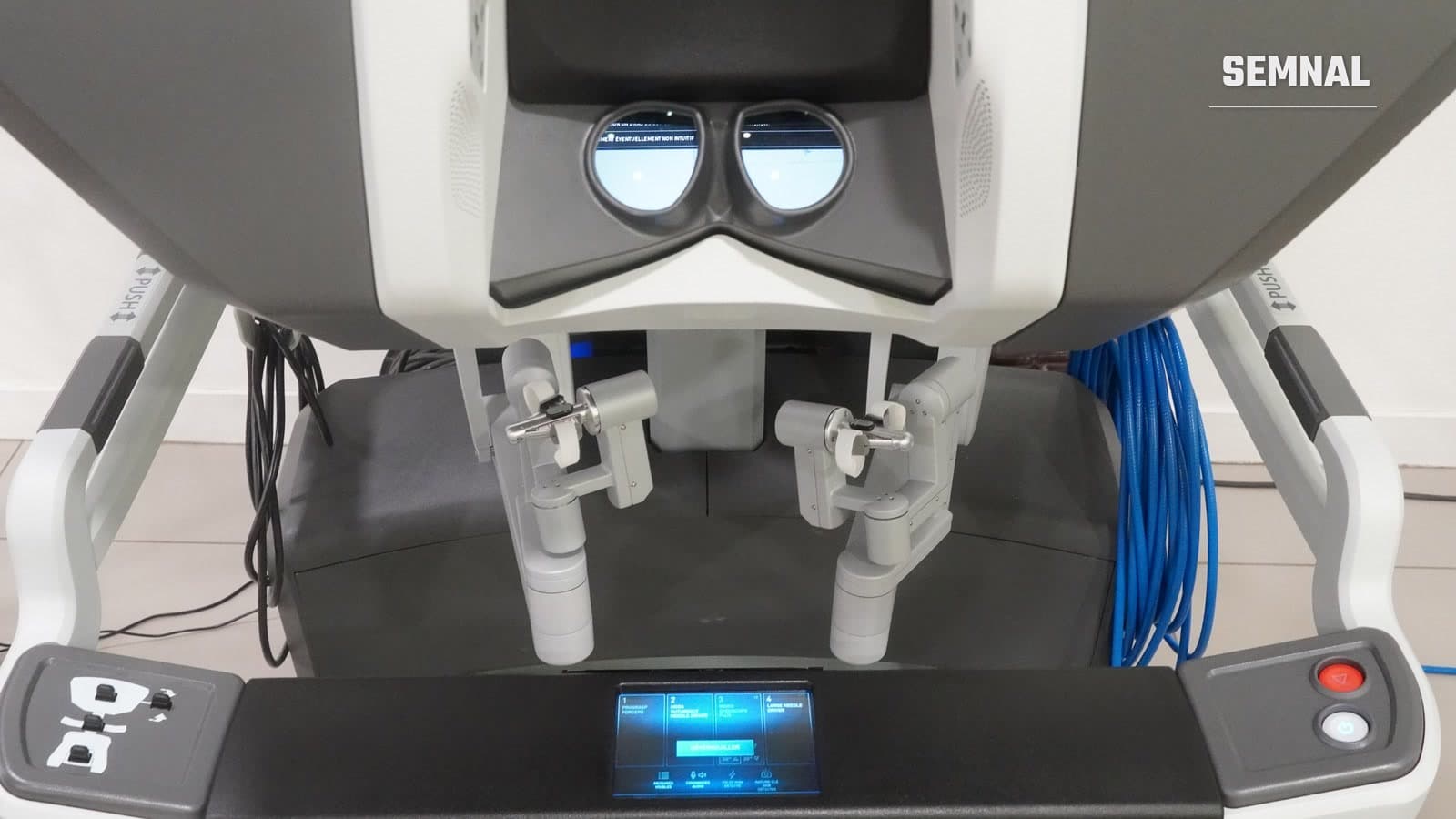 Consola chirurgului unui robot chirurgical da Vinci Xi, cu vizor stereoscopic, mânere de comandă și ecran tactil, într-un spital din Vesoul, Franța