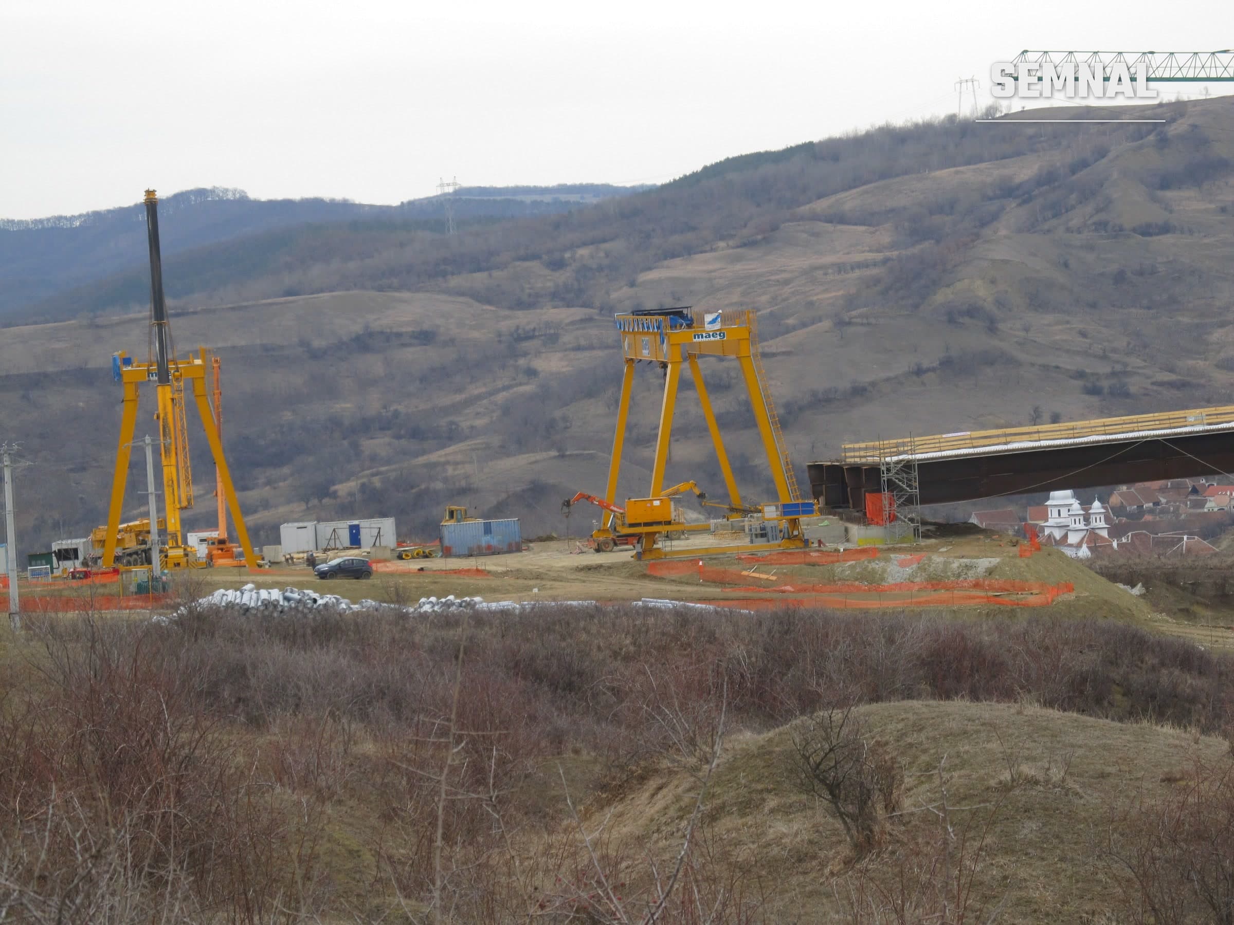 Viaduct de autostradă în construcție în România, cu macarale galbene pe un deal; imagine ilustrativă, nu este tronsonul Lețcani-Iași