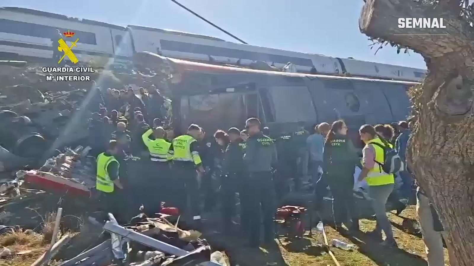 Agenți ai Guardia Civil și salvatori lângă vagoanele răsturnate ale trenului lovit la Urda, provincia Toledo