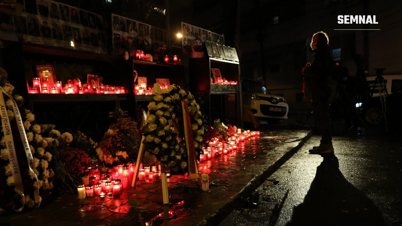 Lumânări aprinse, flori și fotografiile victimelor în fața fostului club Colectiv din București, seara, la comemorare