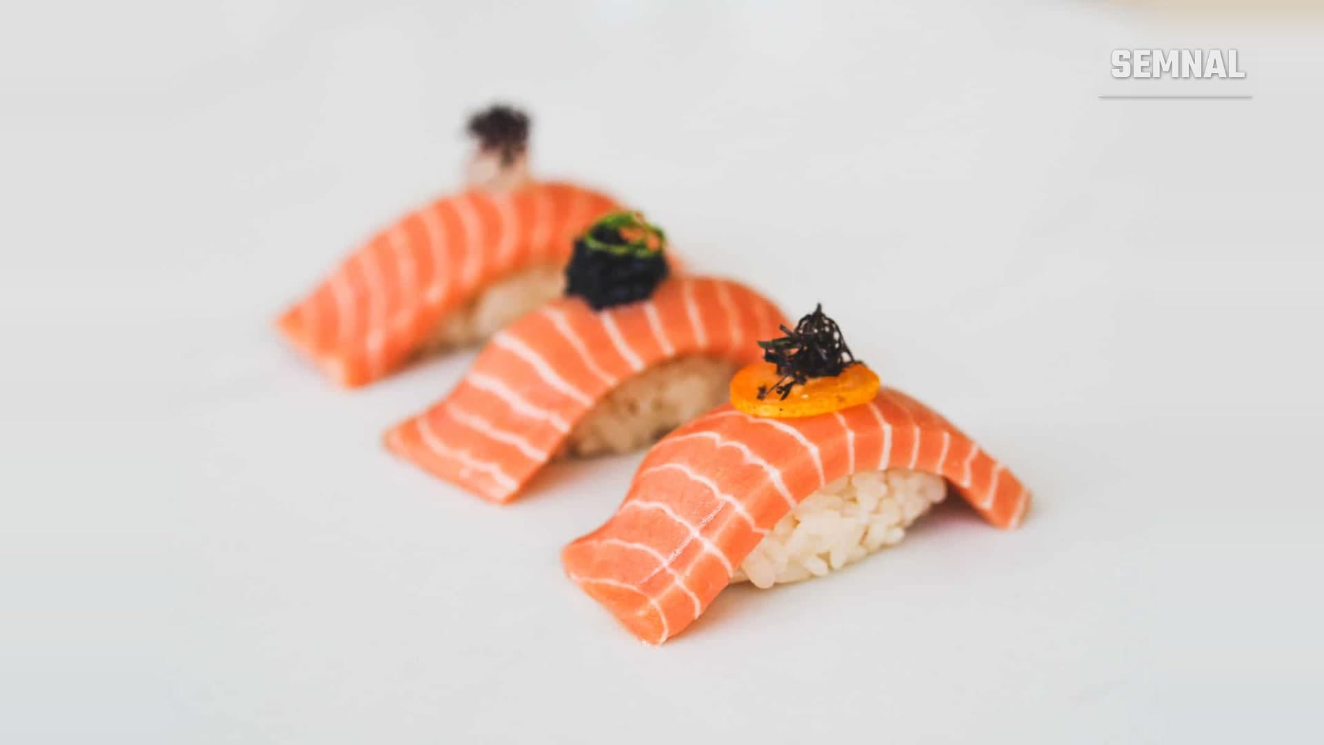 Trei bucăți de nigiri cu somon cultivat Wildtype, pe fundal alb