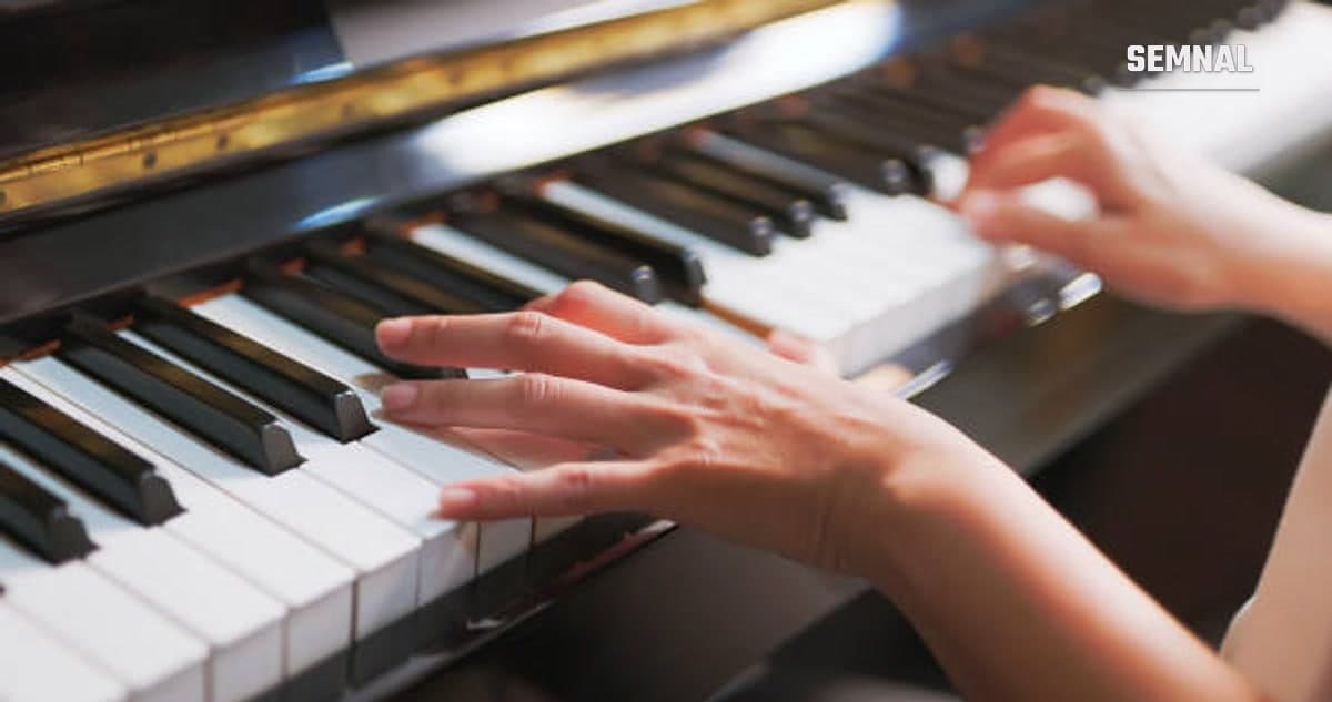 În imagine se văd mâinile unui pianist cântând la pian.