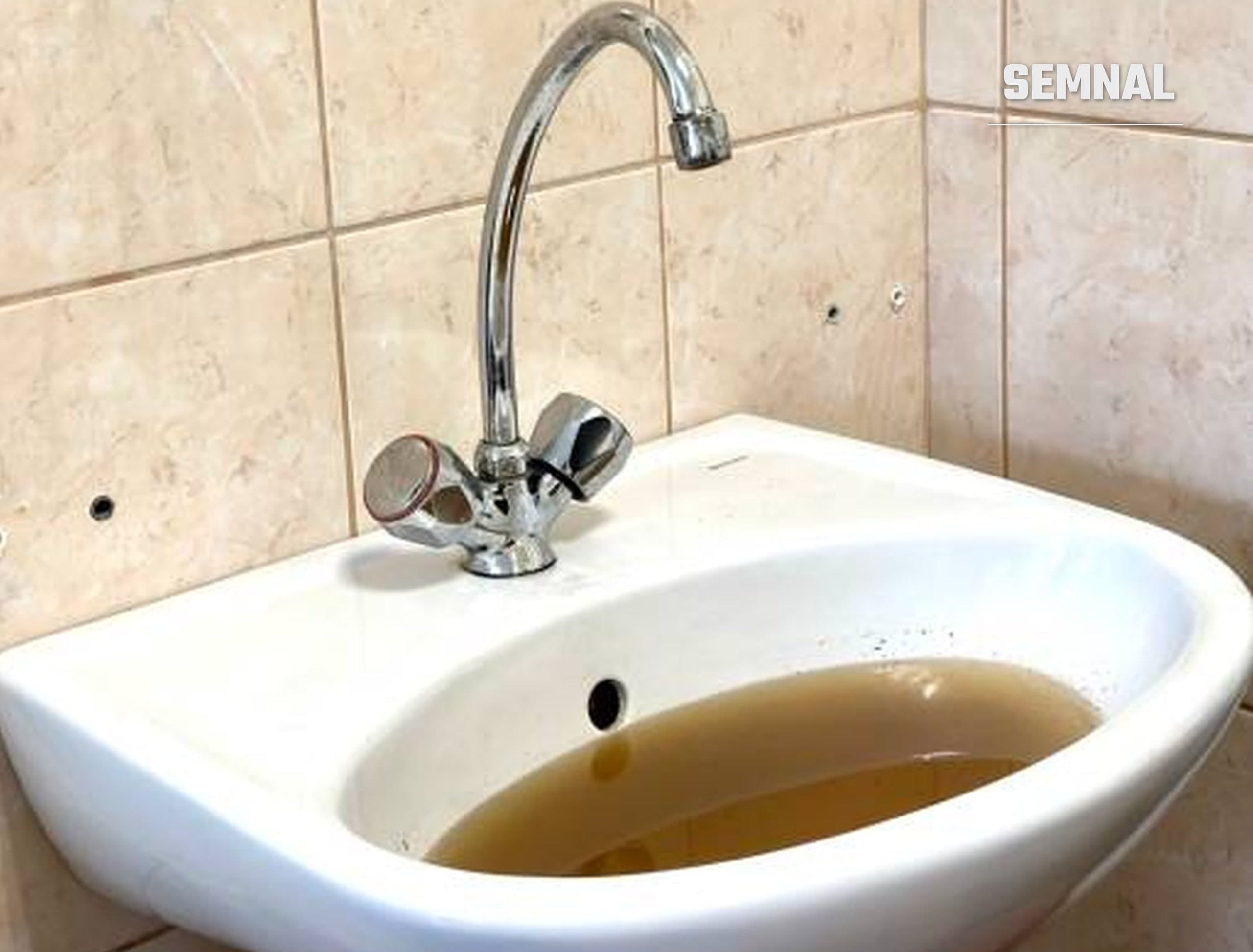 În imagine este o chiuvetă plină cu apă murdară.