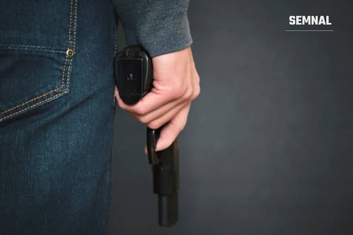 Imagine ilustrativă cu un bărbat care ține în mână un pistol.