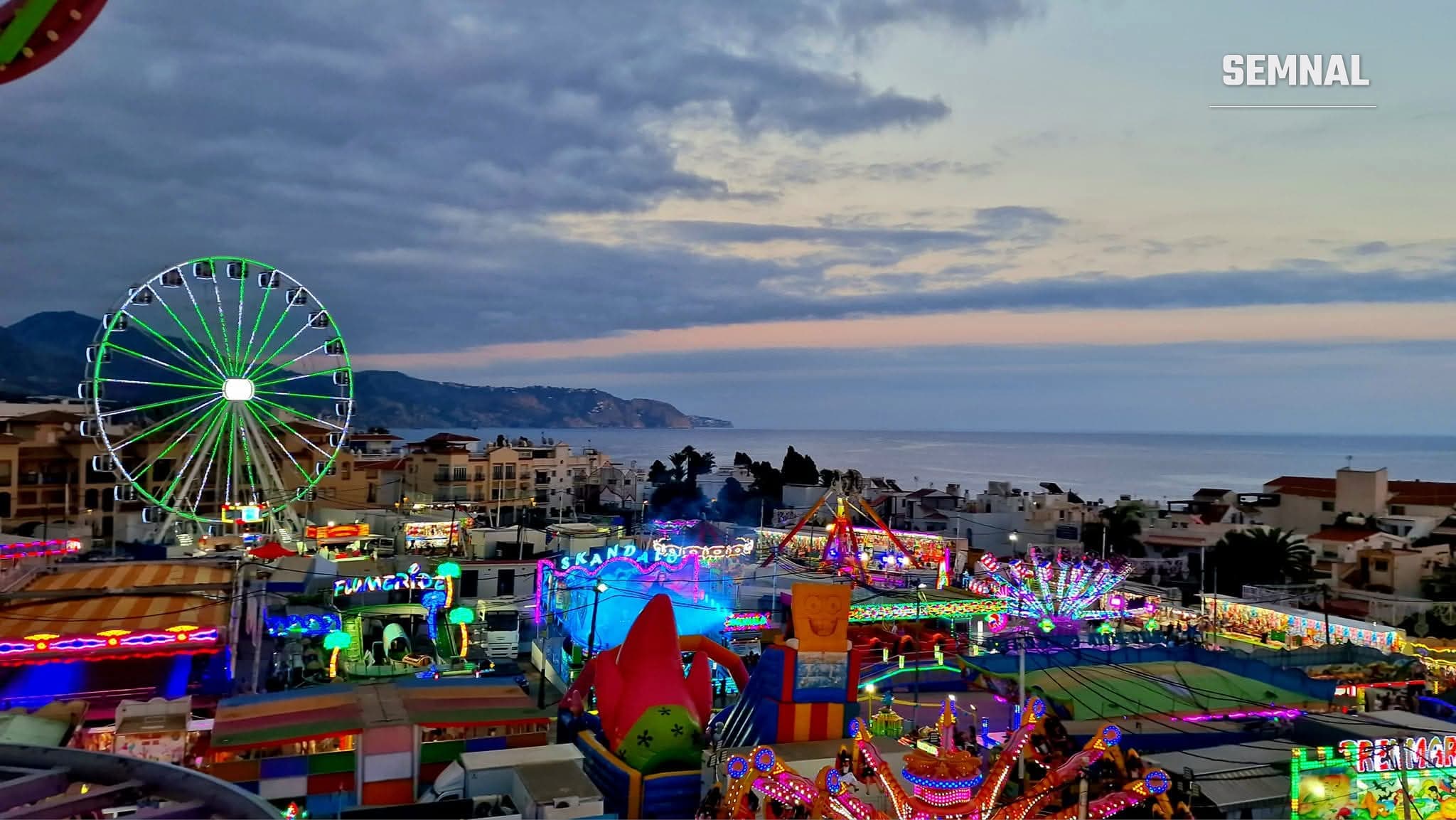 Imagine de sus din roller-coaster cu o roata la feria din Nerja