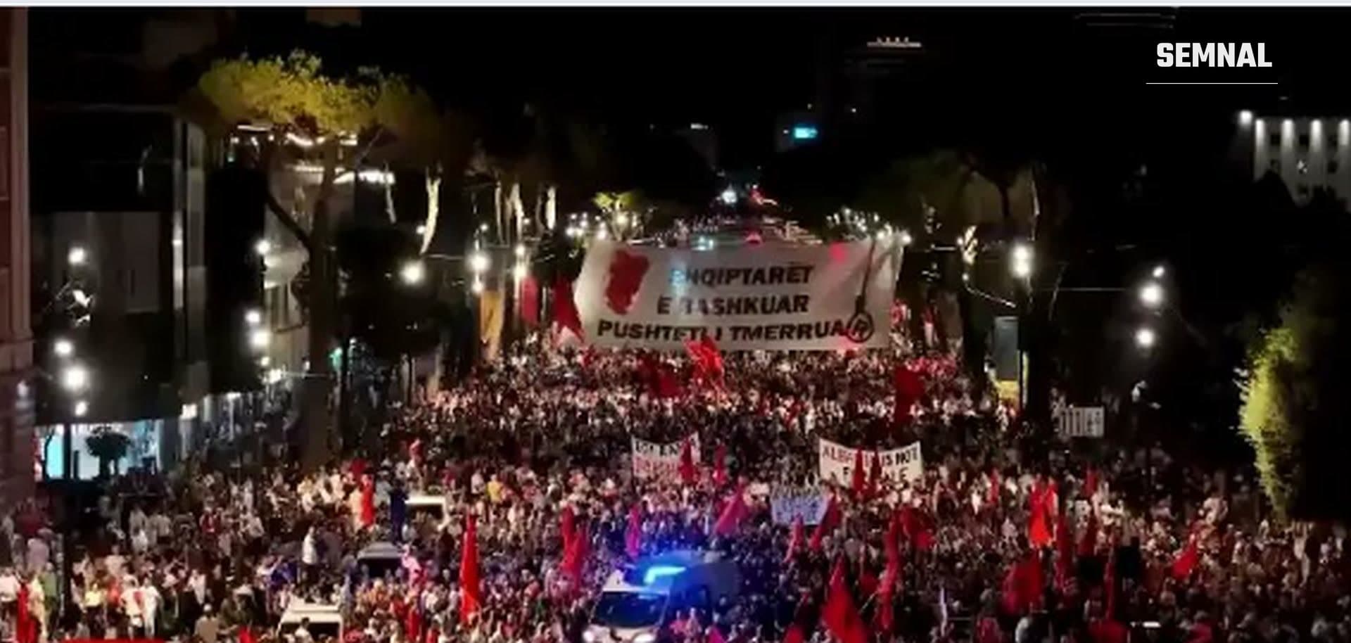 În imagine sunt zeci de albanezi care au ieșit în stradă, la protest, la Tirana, purtând steaguri roșii.