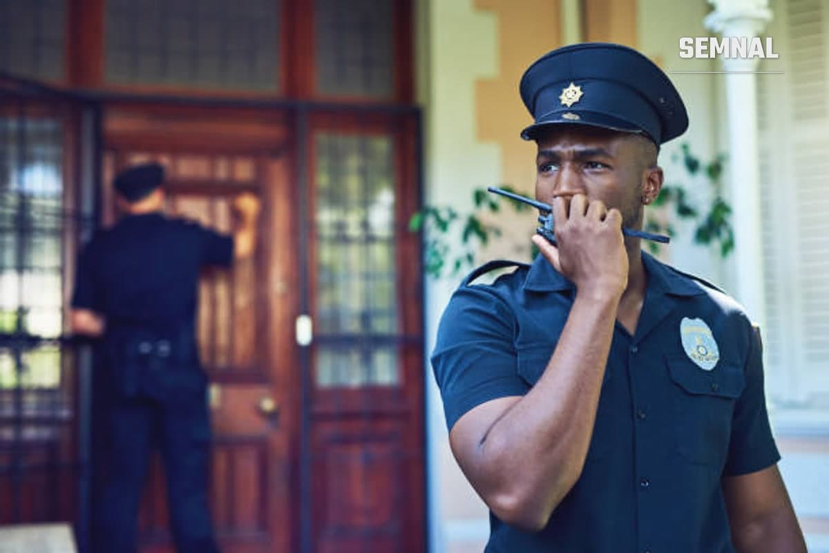 În imagine este un politist din  Africa de Sud care vorbește la o stație de emisie-receptie.