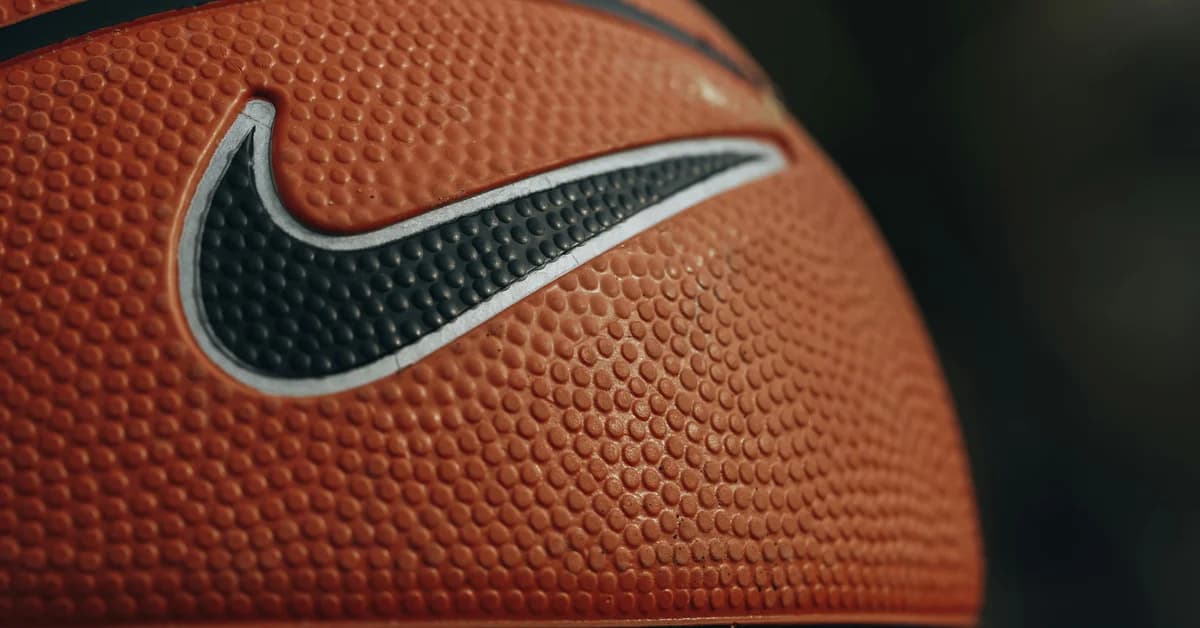 Minge de baschet portocalie cu logo-ul Nike, linii negre și textură noduroasă pe suprafață.