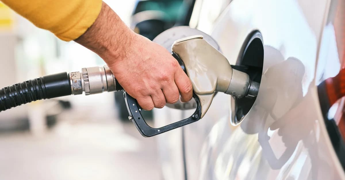 O persoană alimentează o mașină la o pompă de benzină, pe fondul creșterii prețurilor carburanților la nivel mondial