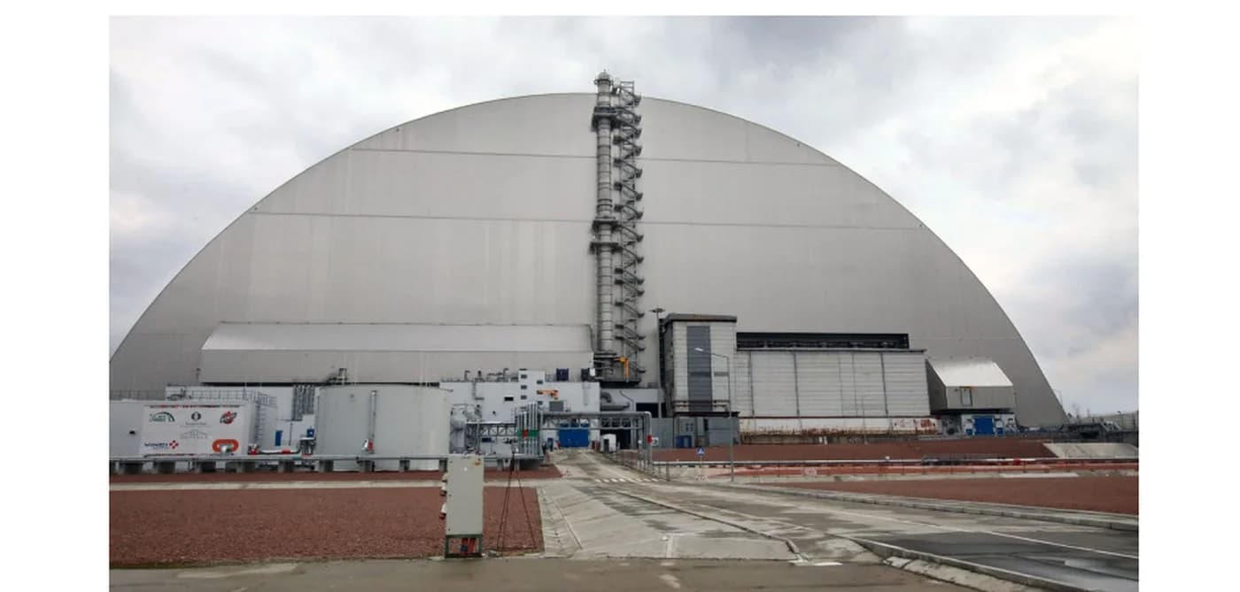 Vedere exterioară a unei centrale nucleare cu dom de protecție și echipamente industriale, ilustrând infrastructura unei instalații de generare de energie nucleară în situație de criză operațională.