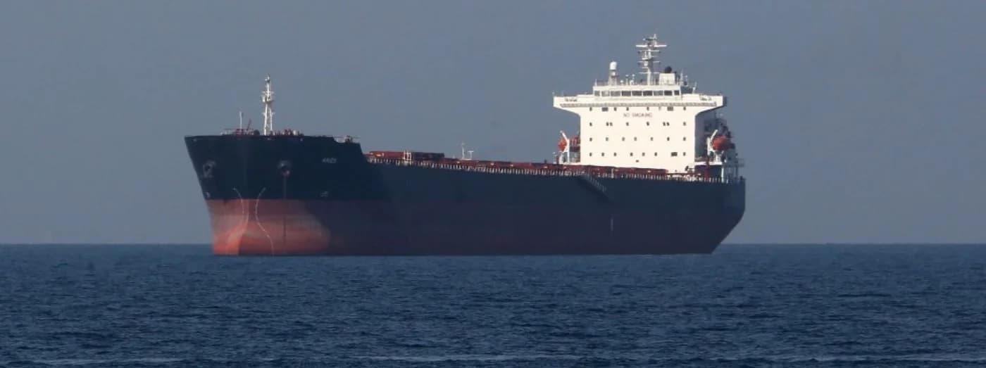 Petrolier de mari dimensiuni cu carcasă neagră și suprastructură albă, fotografiat pe mare deschisă, cu urme de vopsea roșiatică pe burtă, semn al deteriorării sau avarierii navei.