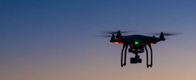 Drone flying over ocean at dawn