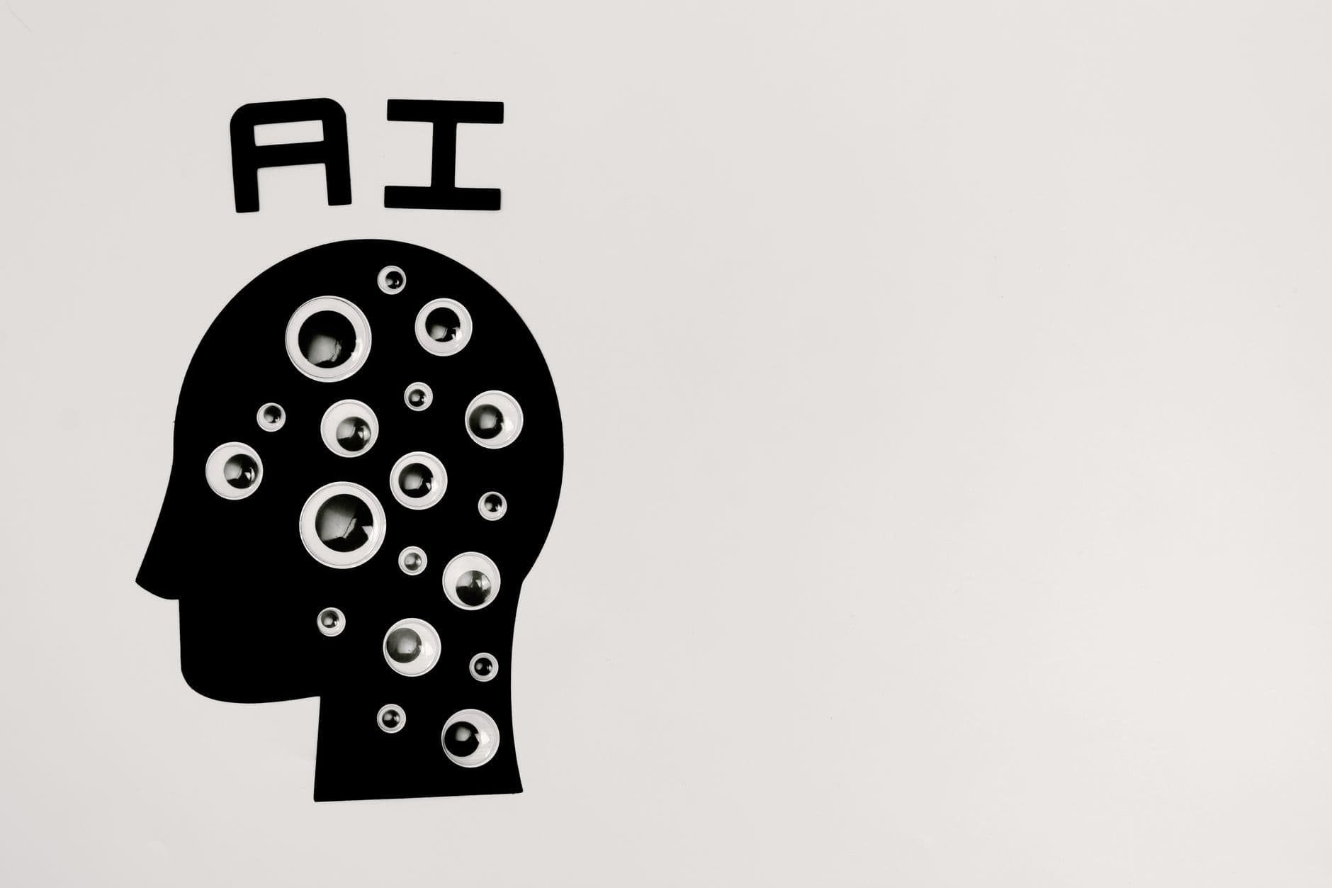 Siluetă neagră a unui cap uman din profil plină cu ochi de jucărie și literele AI deasupra, ilustrație conceptuală despre inteligența artificială
