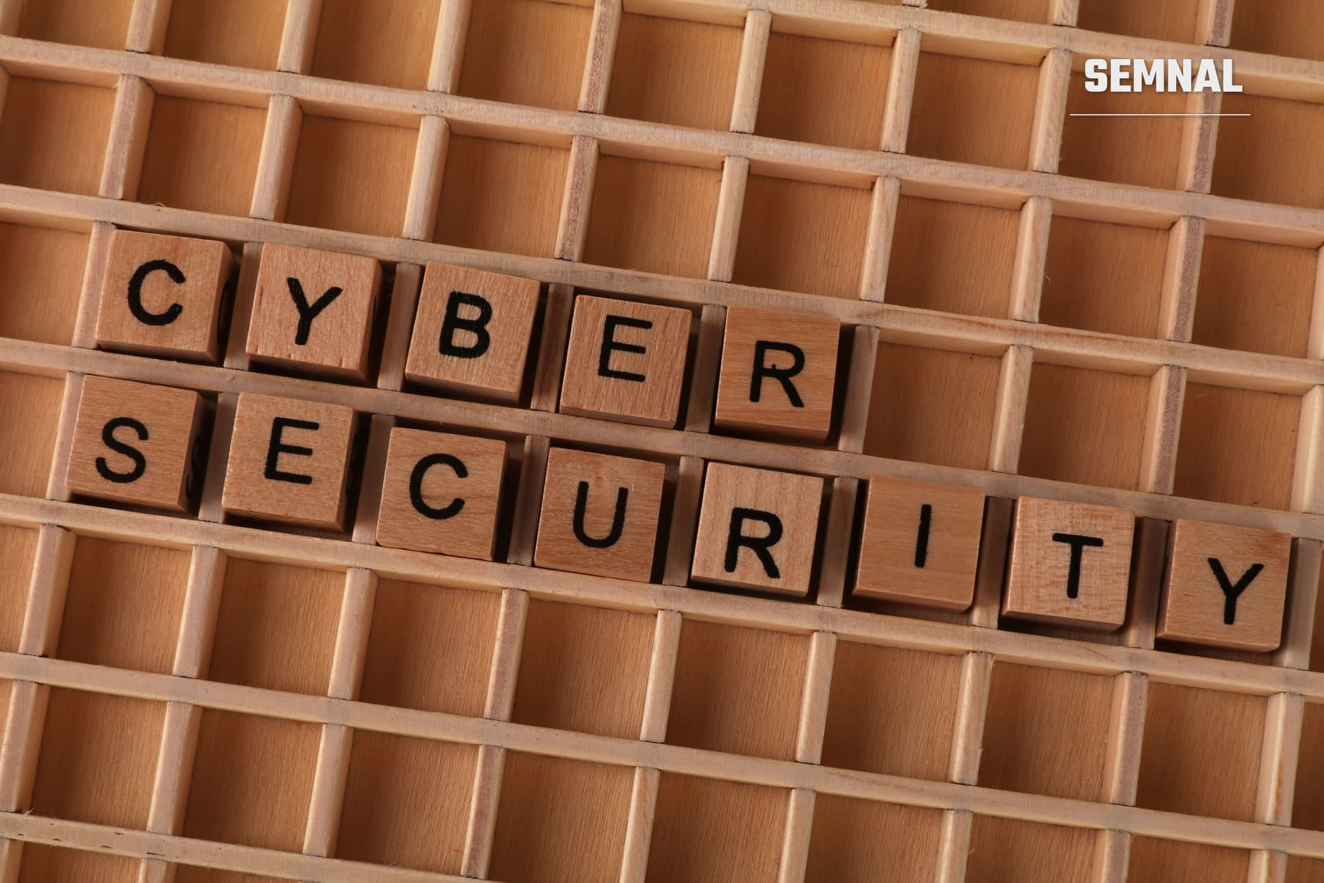 Cuburi de lemn cu litere in cutie cu compartimente alcatuind cuvintele CYBER SECURITY, reprezentand securitatea parolelor si protectia datelor personale