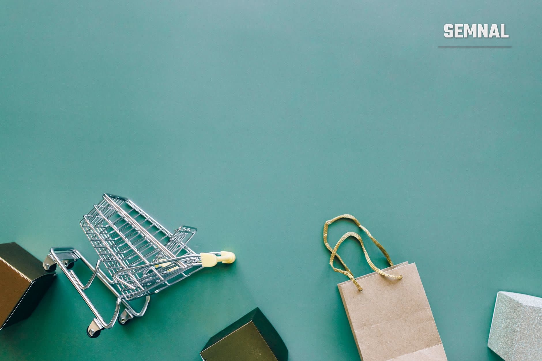 Cos de cumparaturi metalic argintiu si punga de cumparaturi din hartie pe fundal turcoaz, simbolizand cumparaturile online si protectia consumatorului