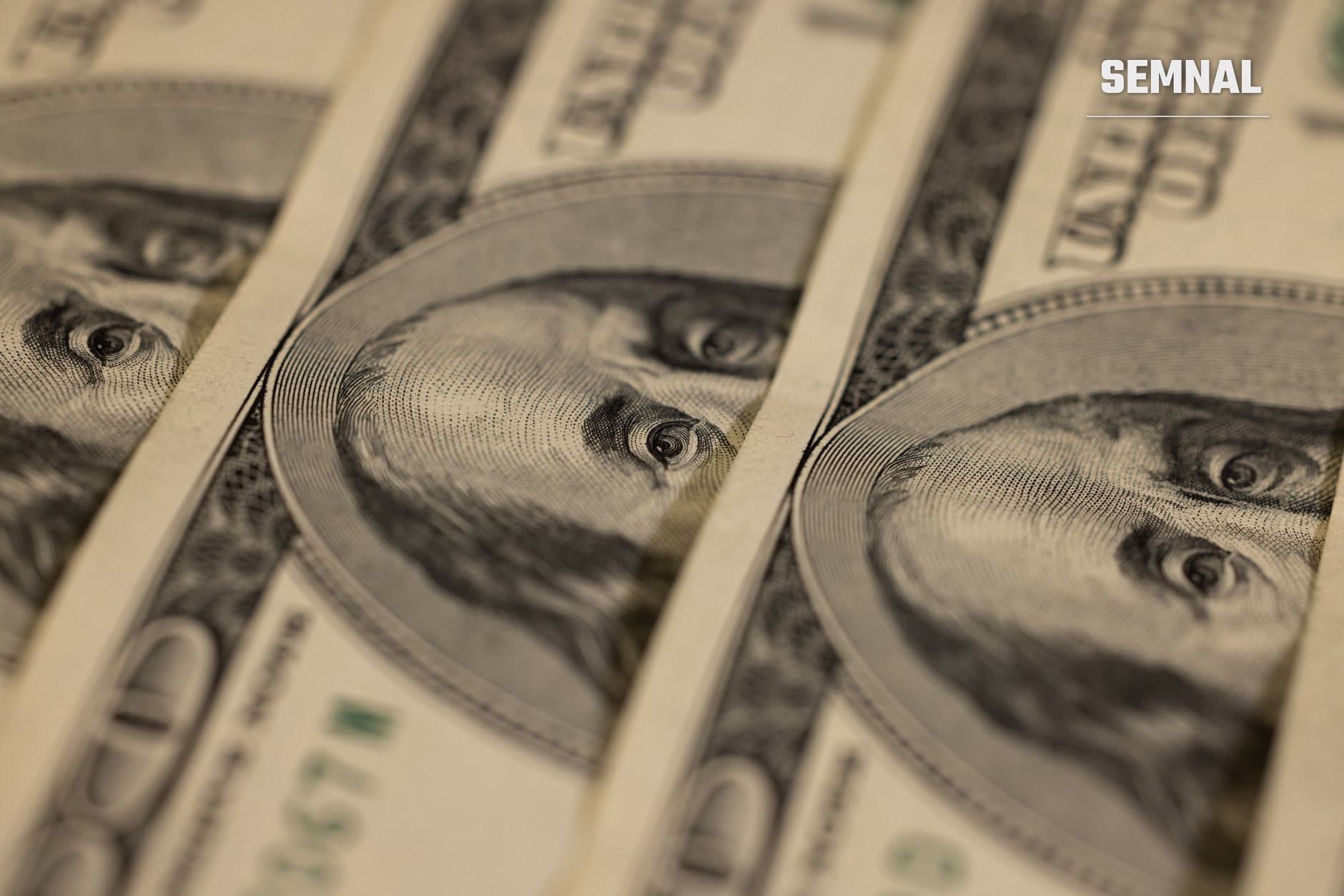 Detaliu macro al mai multor bancnote de dolar american cu portretele gravate și textura de tipar în intaglio, ilustrând contextul financiar și valutar al datoriei SUA.