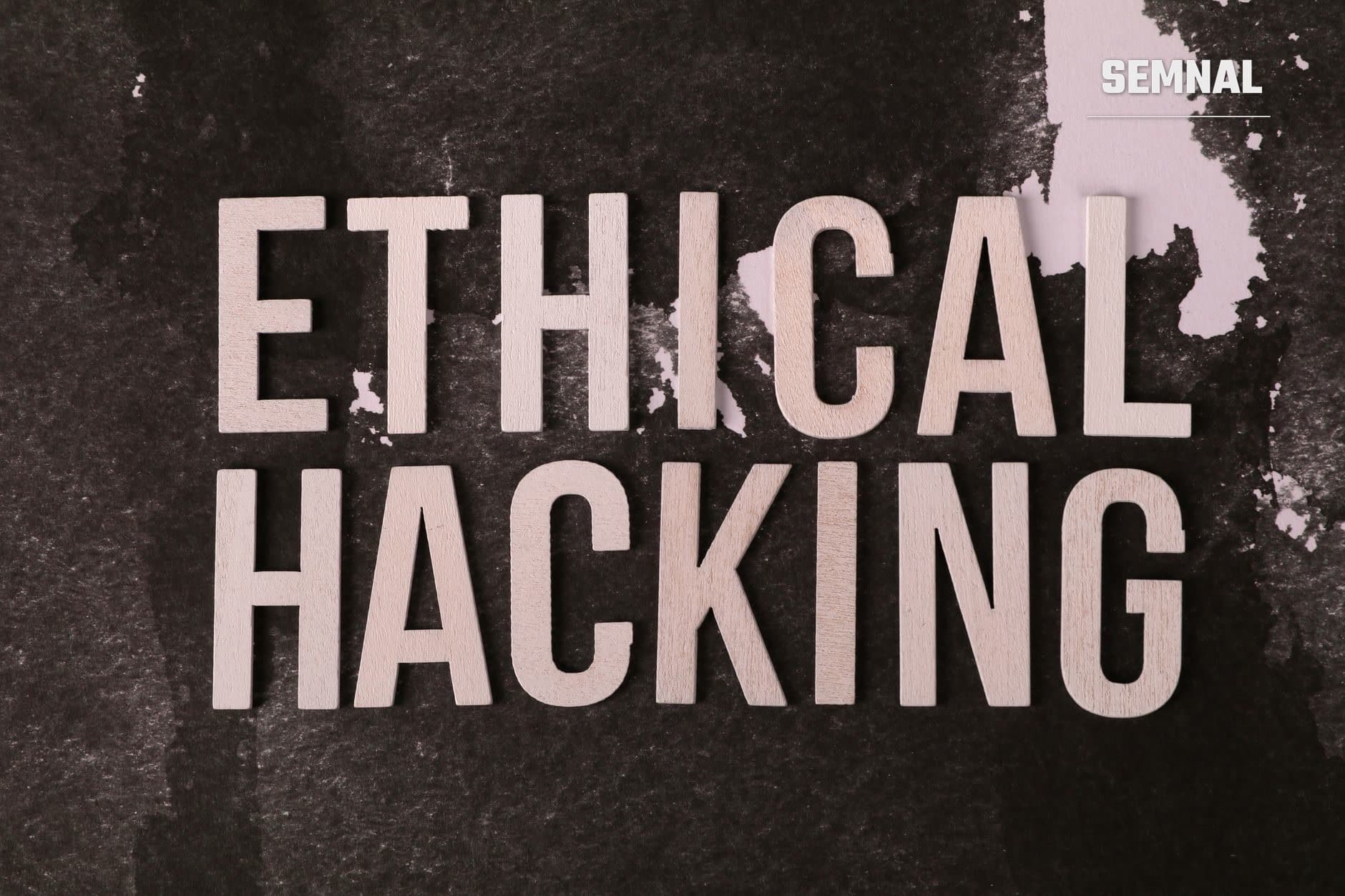 Text alb "ETHICAL HACKING" pe suprafață de ciment gri deteriorat, ilustrând tema atacurilor cibernetice și securității informatice.