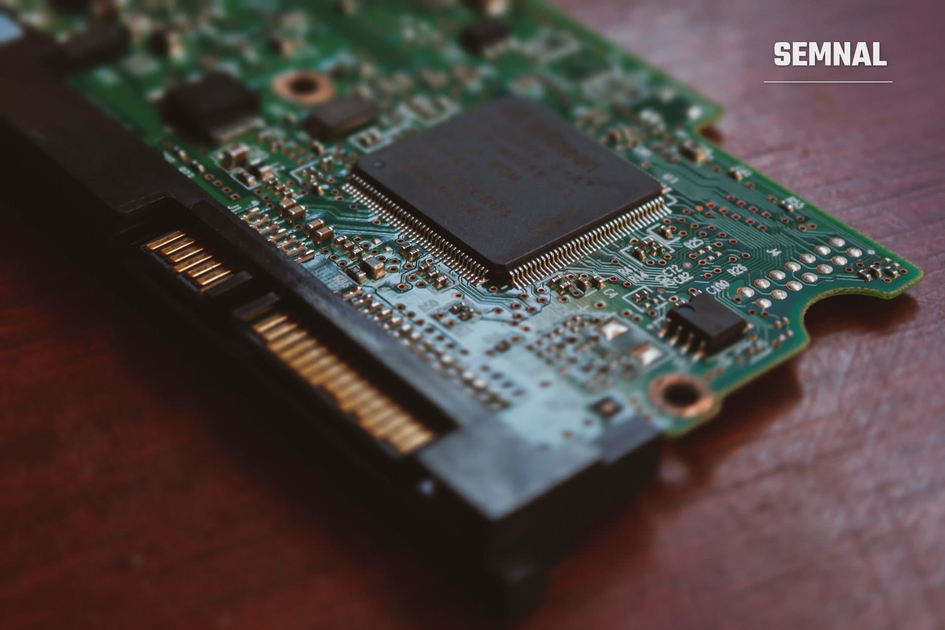 Detaliu al unui cip semiconductor montat pe placă cu circuite verzi și componente electronice, reprezentând industria cipurilor din Coreea de Sud.