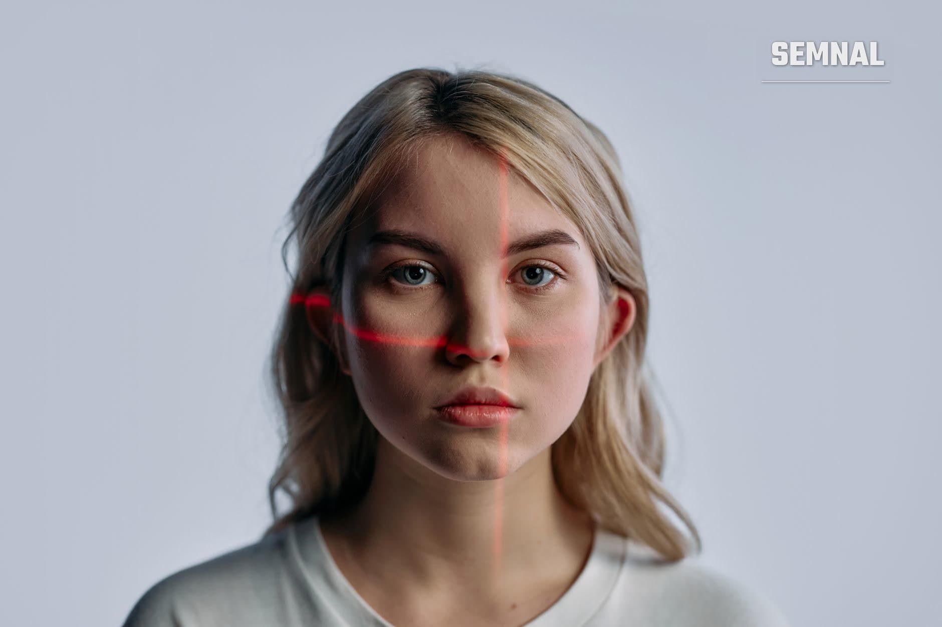 Portret frontal al unei femei cu o linie roșie de scanare digitală proiectată pe fața ei, ilustrând tehnologia de recunoaștere facială și supraveghere biometrică.
