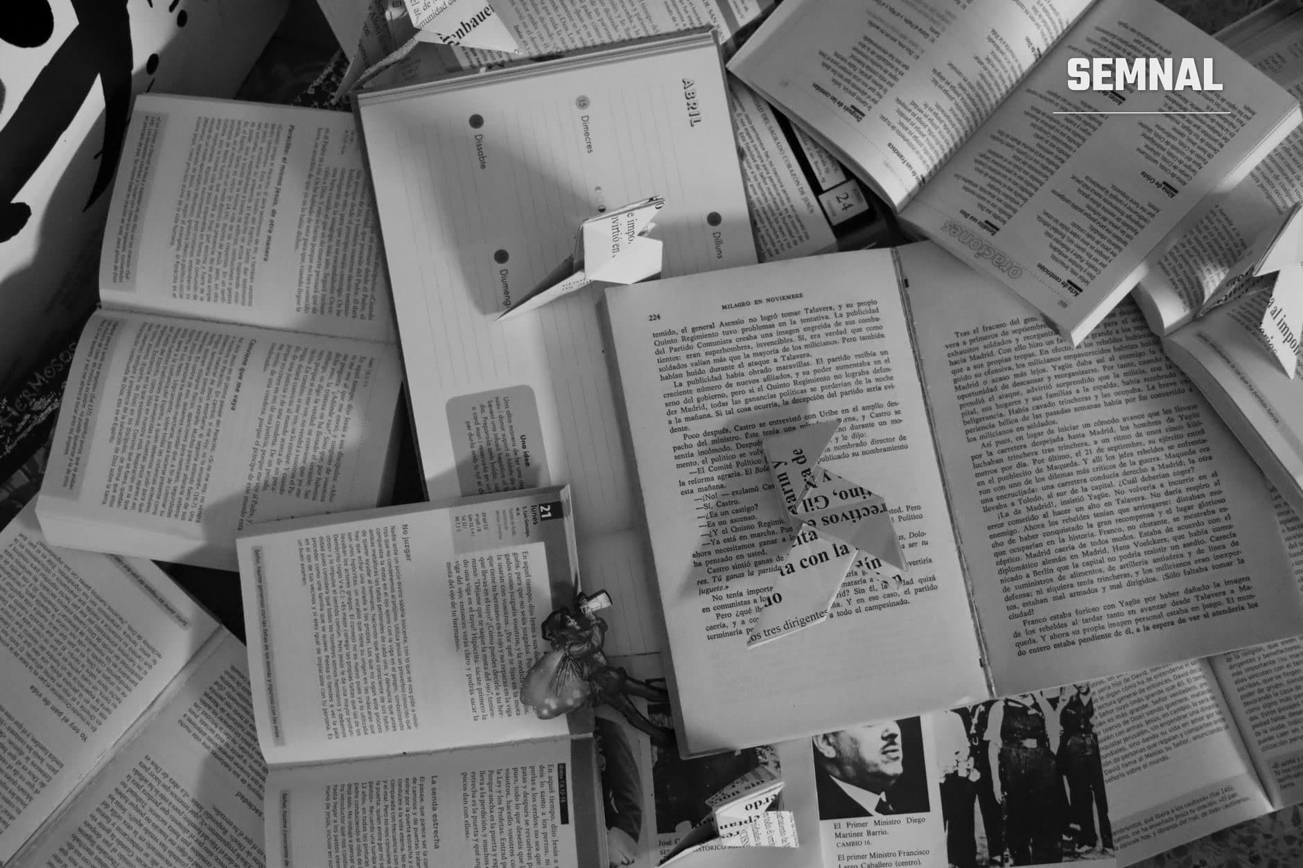 Cărți deschise și documente tipărite cu text în limba spaniolă, răspândite pe o suprafață - ilustrație pentru articol despre interzicerea importului de materiale de lectură și presă (Foto: Nacho Abad / Pexels)