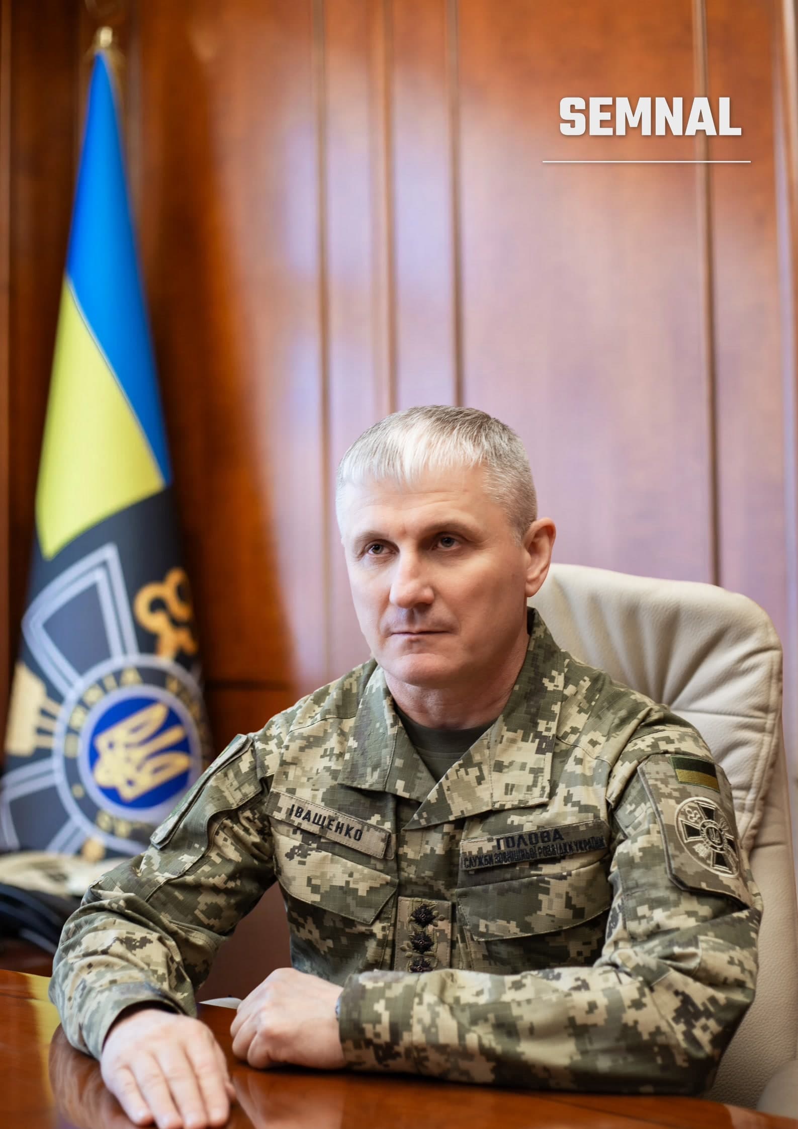 Oleh Ivașcenko, locotenent general, șef, pozat la birou într-o uniformă militară de camuflaj digital, cu steag ucrainean în spate. (Foto: Служба зовнішньої розвідки України)