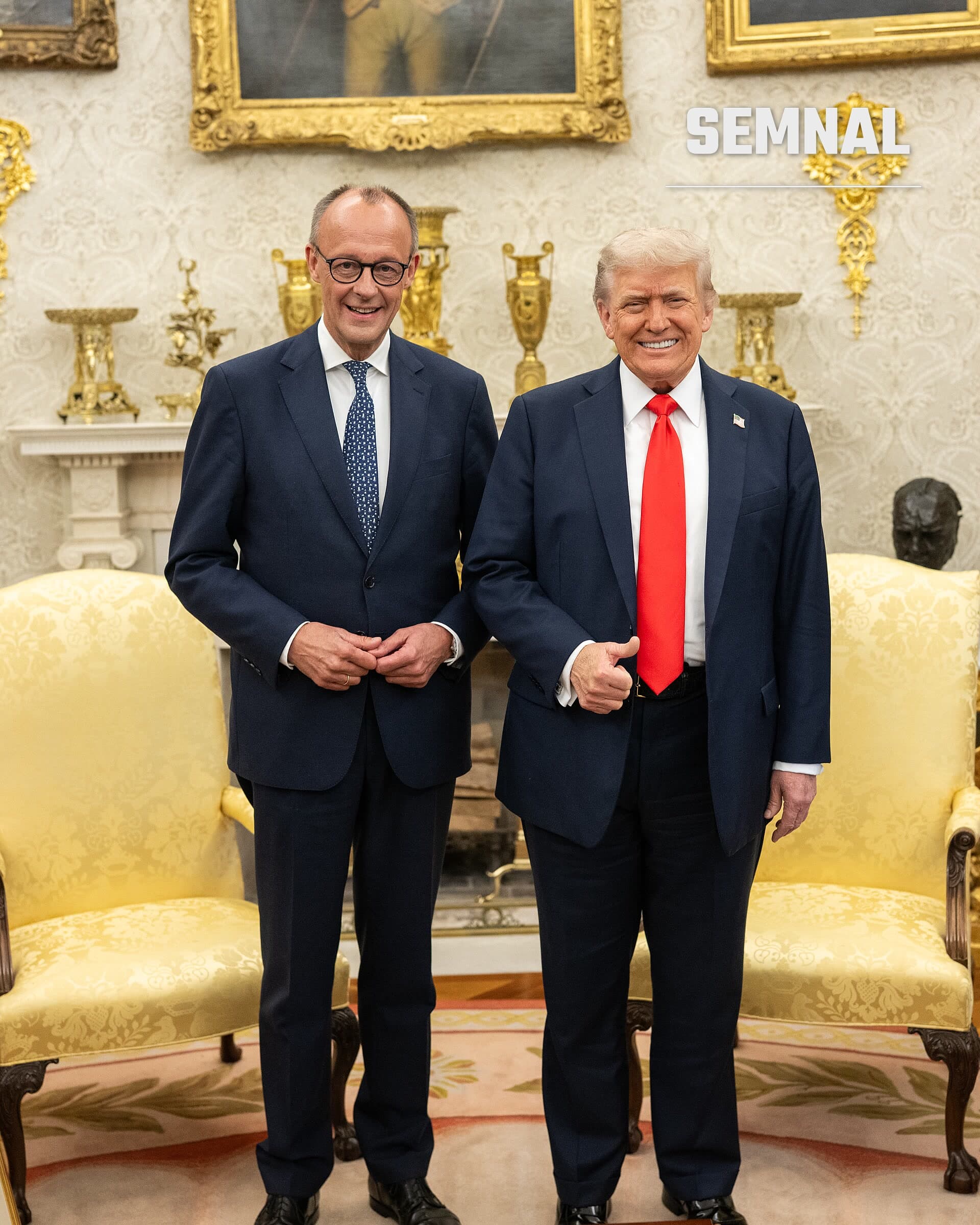 Friedrich Merz, cancelarul Germaniei, zâmbind în timp ce stă în picioare alături de un alt oficial într-o încăpere oficial decorată cu mobilier de lux și tablouri în cadre de aur. (Foto: The White House)