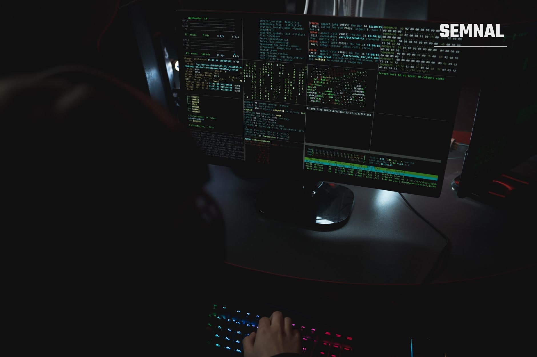 Ecran de calculator cu interfață terminal și cod verde în lumina nocturnă, cu tastatură iluminată RGB în prim-plan, ilustrând activitate tehnică și cybersecurity. (Foto: Tima Miroshnichenko / Pexels)