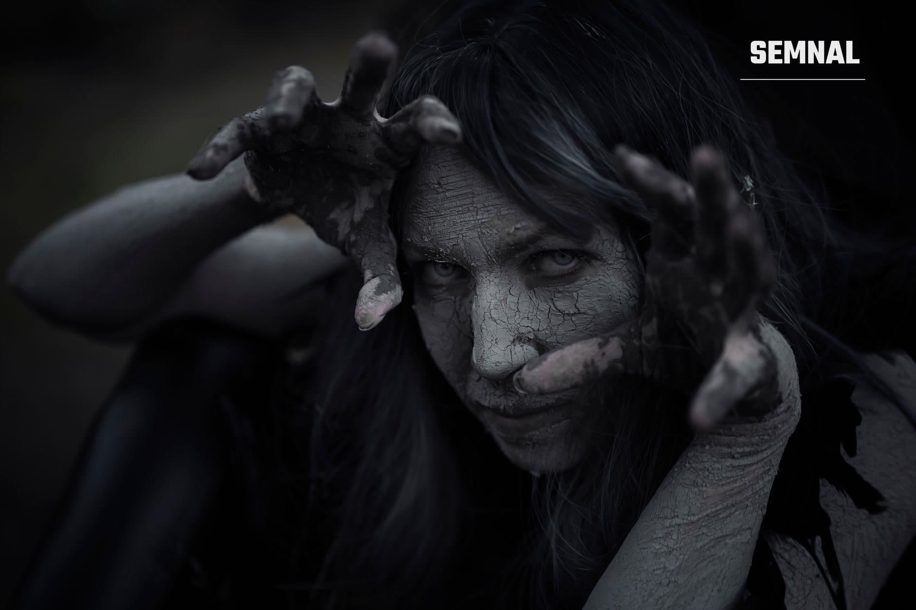 Portret artistic monochrom al unei femei cu expresie de temă și dezgust, mâinile ridicate defensiv, pe fundal negru, ilustrând anxietatea și frica psihologică a unui adult. (Foto: Pedro Dias / Pexels)