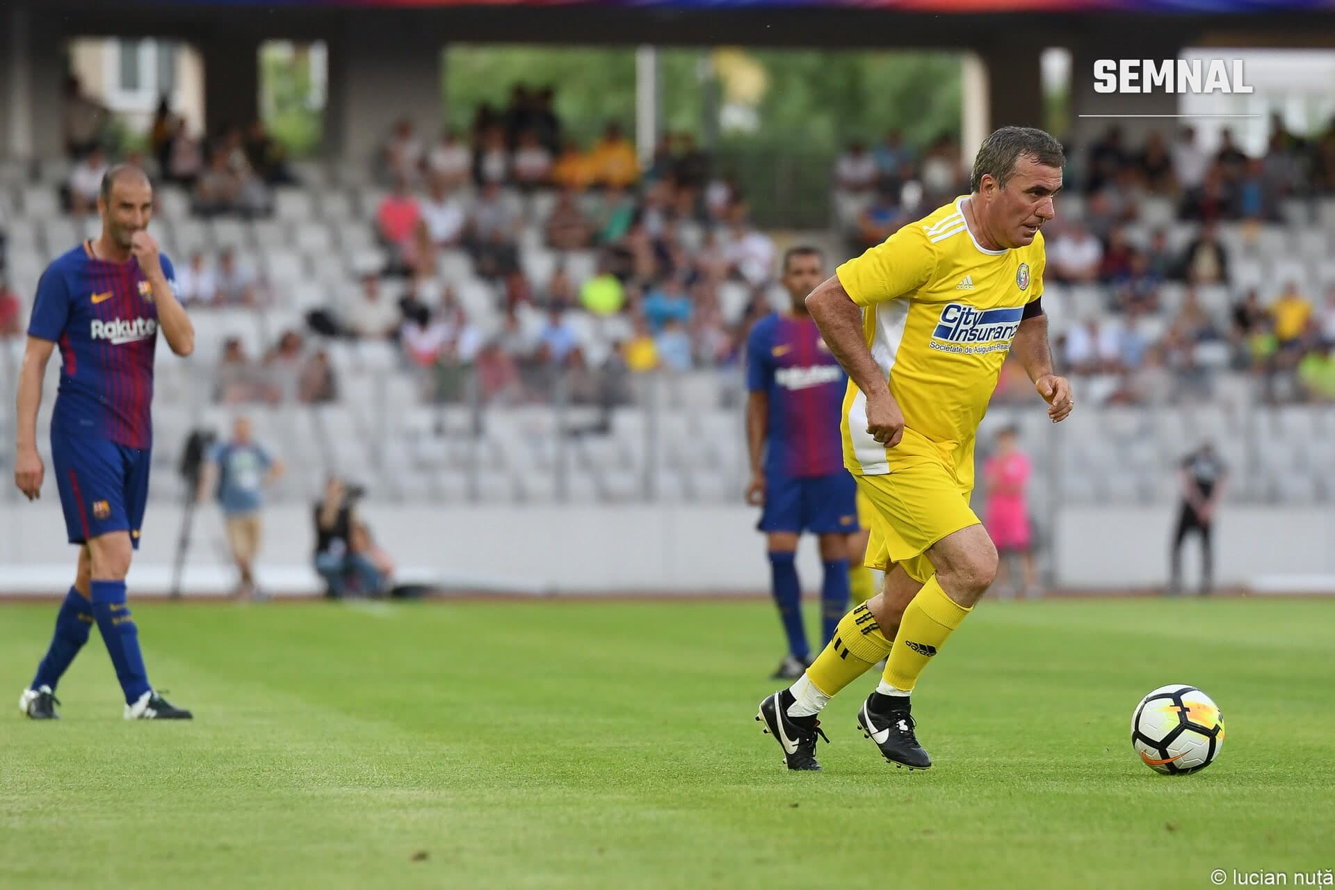 Gheorghe Hagi aleargă cu mingea în echipament galben pe terenul de fotbal, cu fața vizibilă, în prim-plan la un meci. (Foto: Nuță Lucian from Cluj-Napoca, Romania)